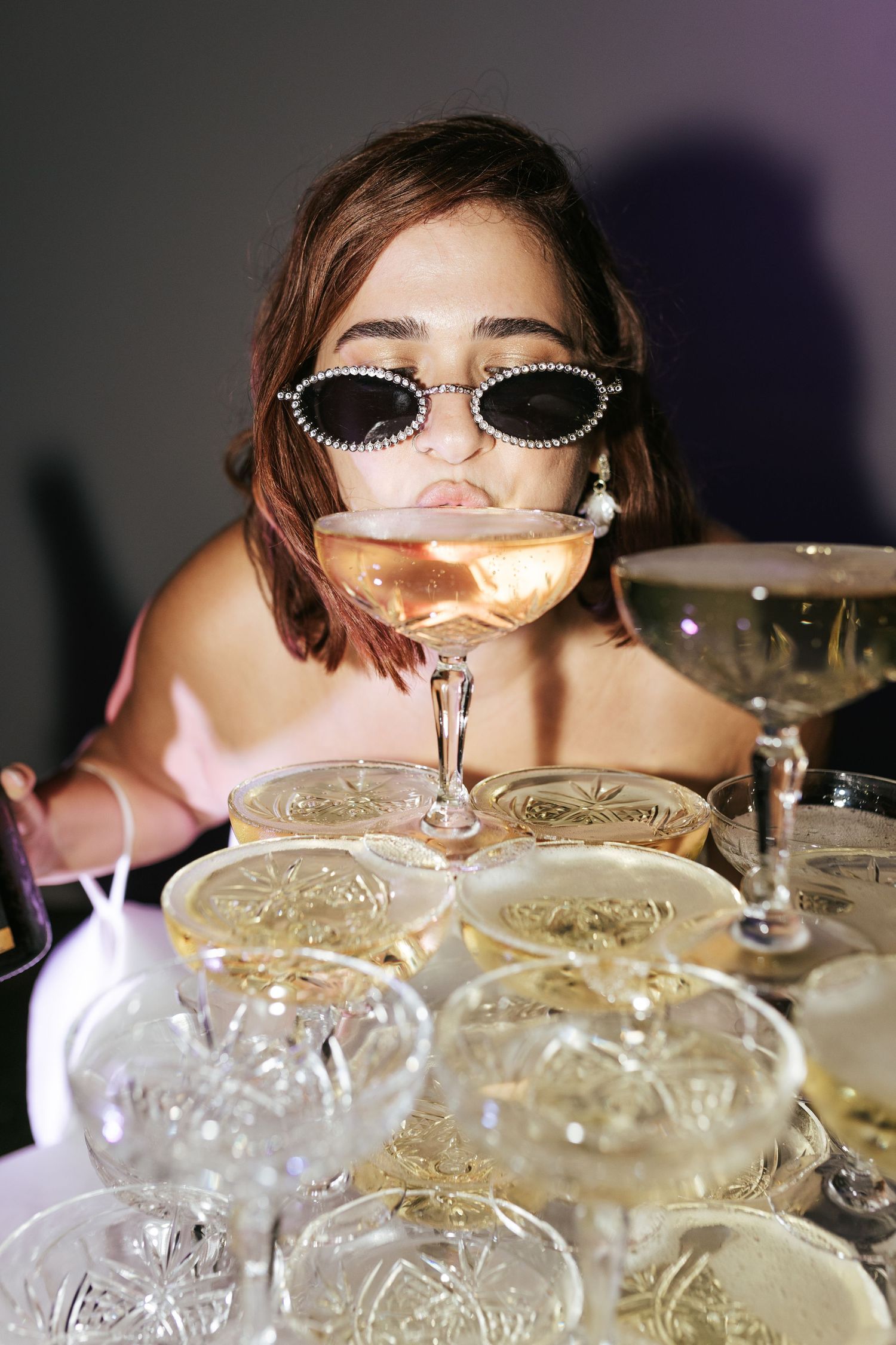 Stylish party scene with stacked champagne coupes and retro sunglasses.