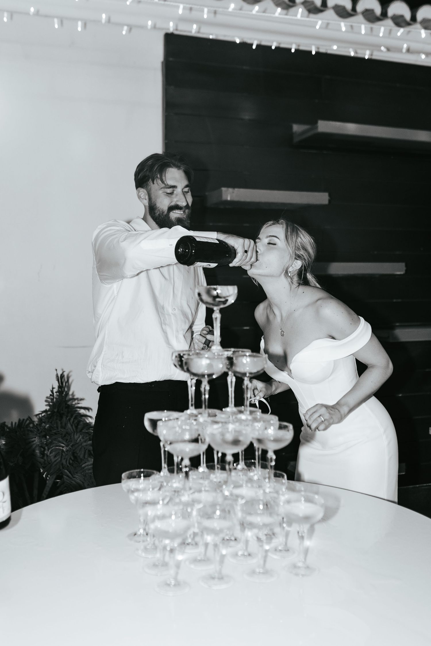 A couple pours champagne into a tower of elegant glasses at their wedding. Taken at Casa do Lago, Quinta do Lago, Portugal.
