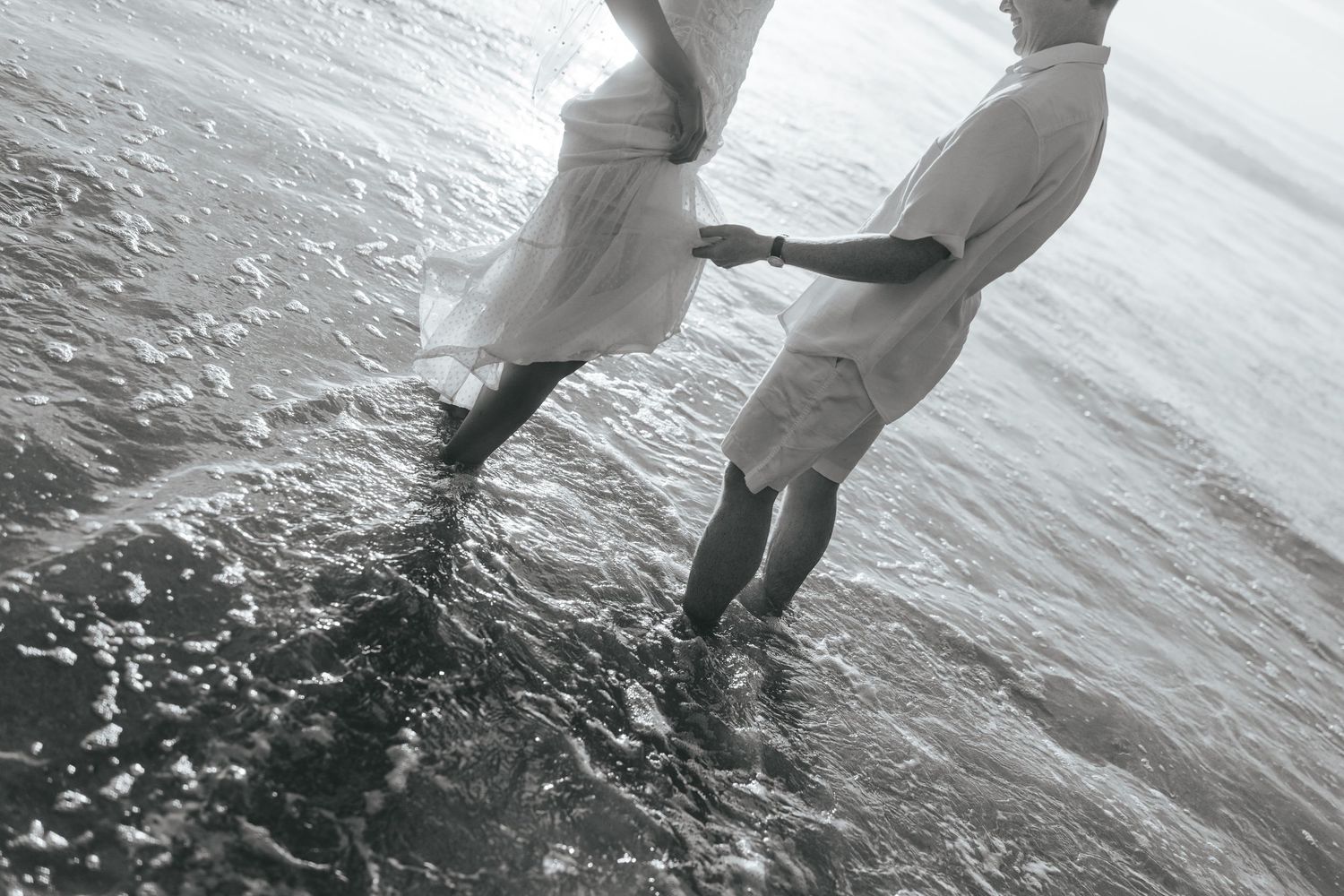 A sequence of black and white photos showing two people dancing together on a beach at the water's edge. Praia do Castelejo, Portugal.