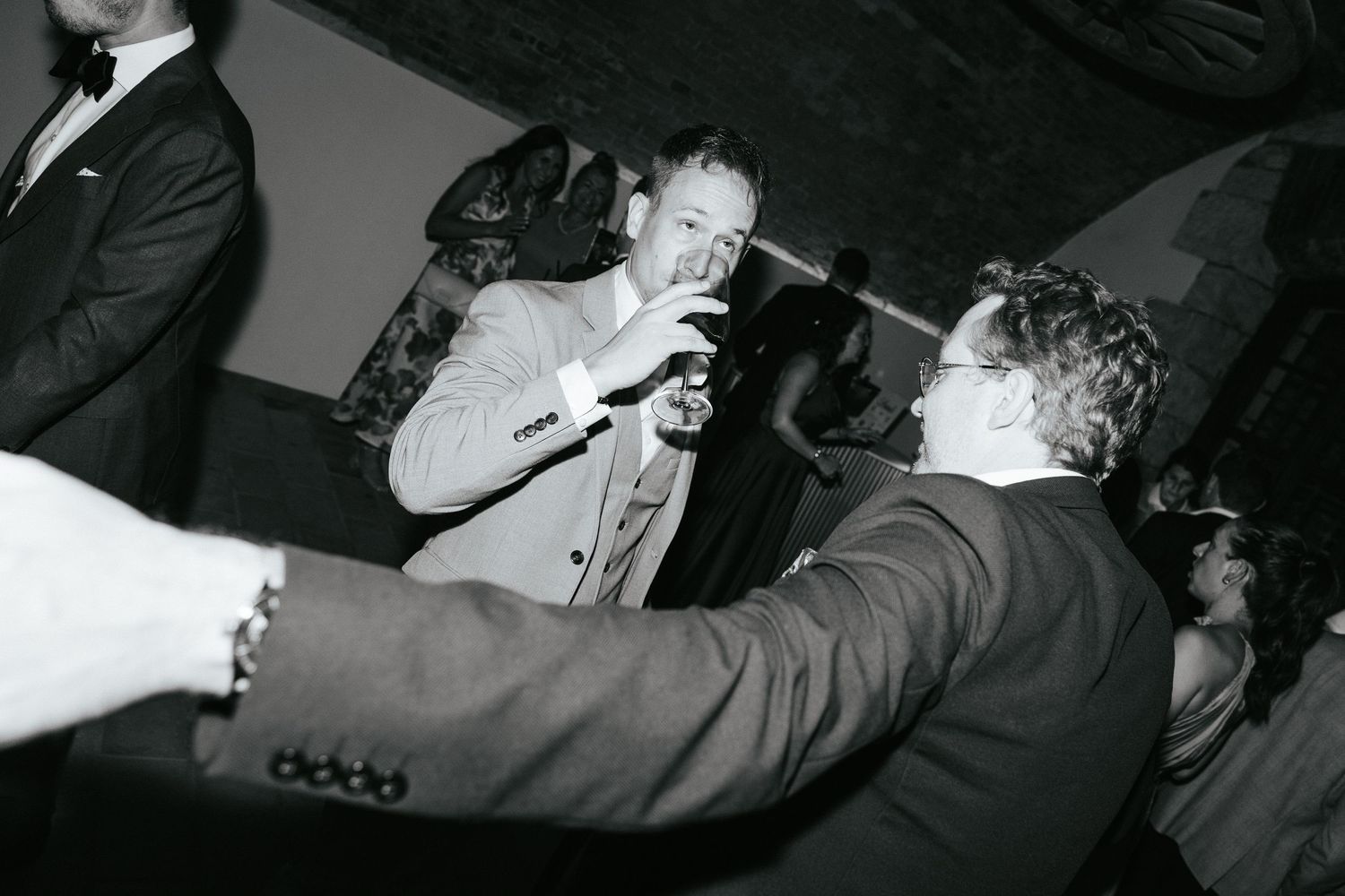 Black and white photos of guests enjoying themselves on the dance floor at a reception.
