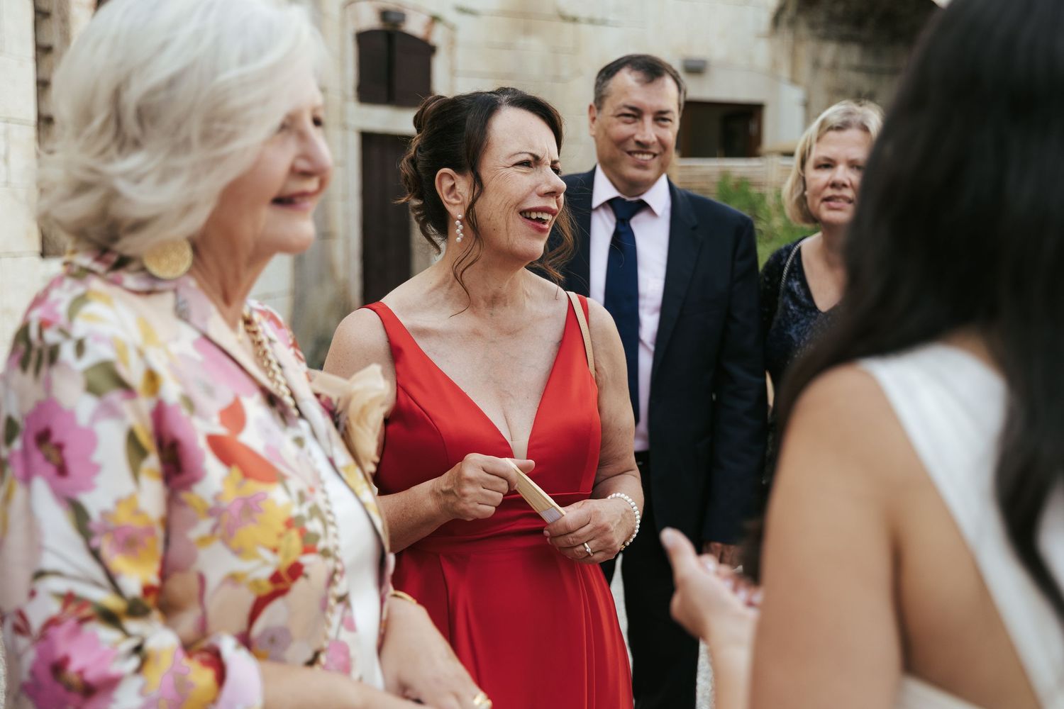 Wedding guests share animated conversations during an elegant outdoor reception.