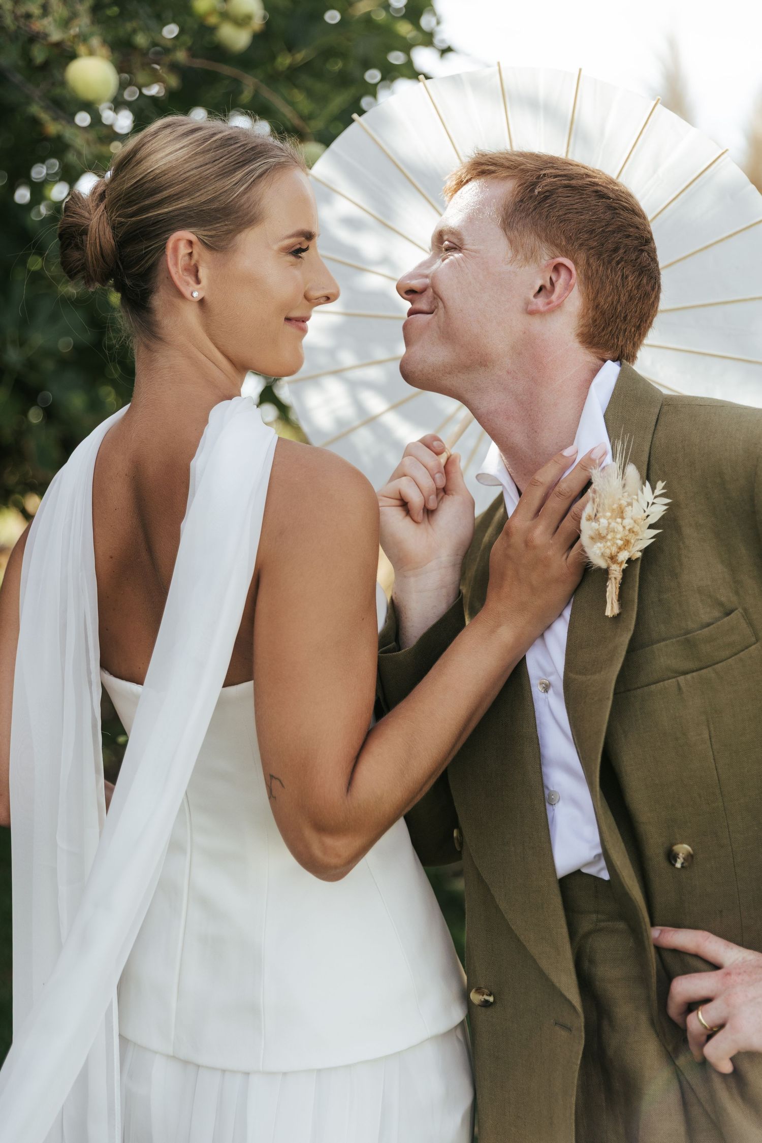 A romantic wedding photo sequence showing a couple sharing intimate moments under a white parasol outdoors.