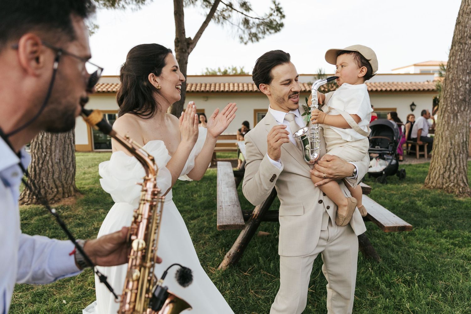 A series of candid wedding photos showing people in white attire dancing and celebrating outdoors in a garden setting.