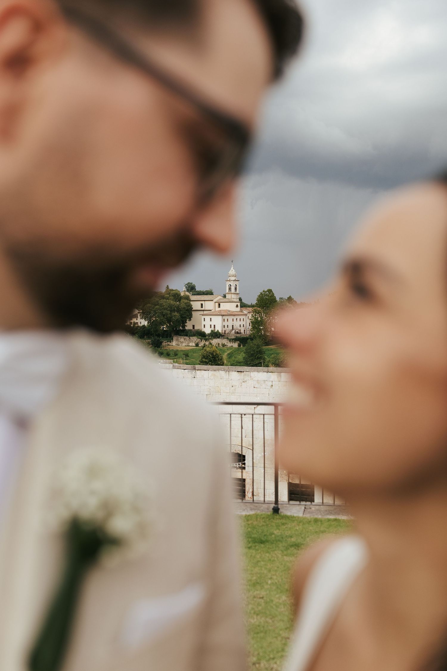 Romantic close-up with church steeple visible in background through soft focus.