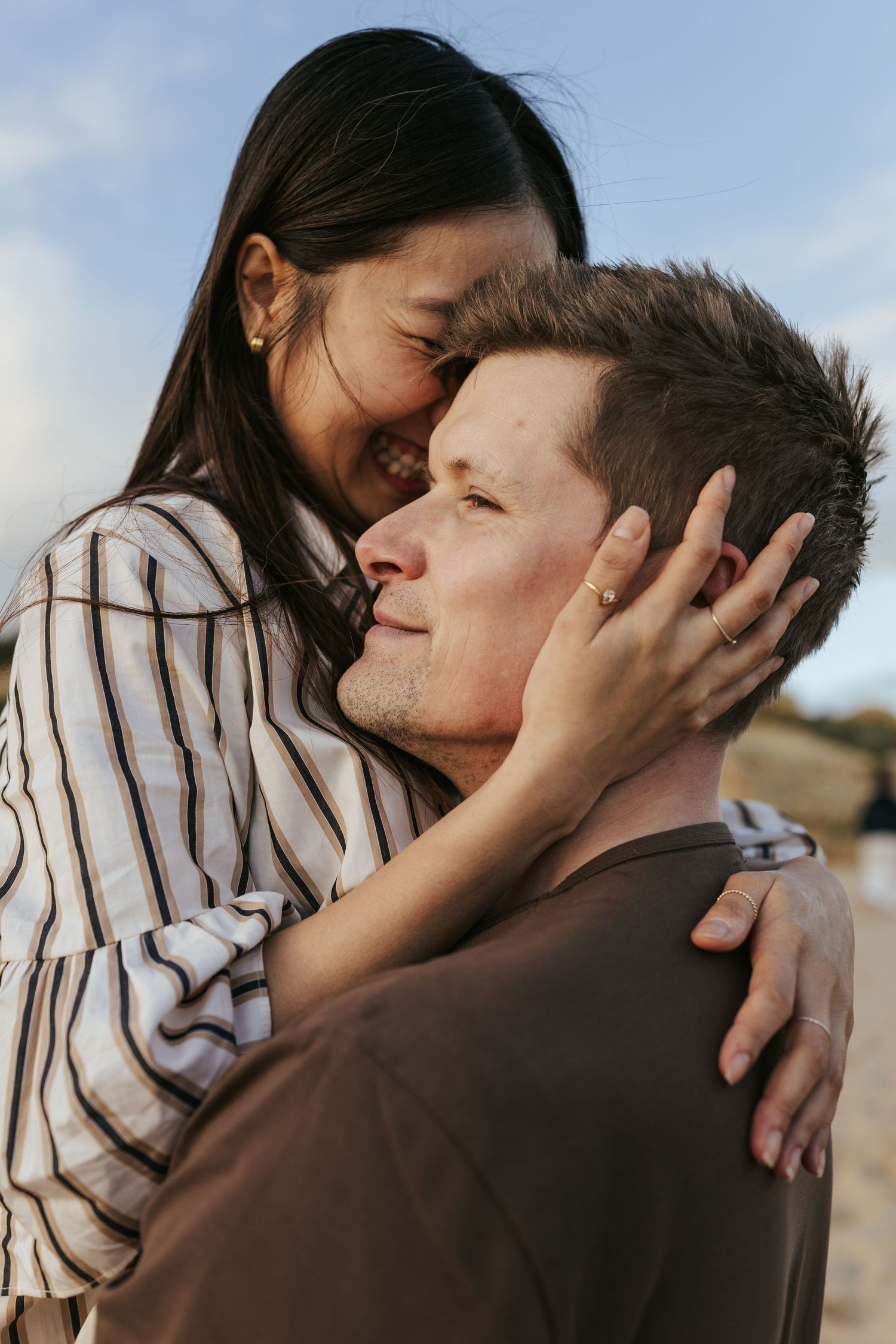 Couple shares an intimate romantic moment outdoors with soft lighting and natural background.