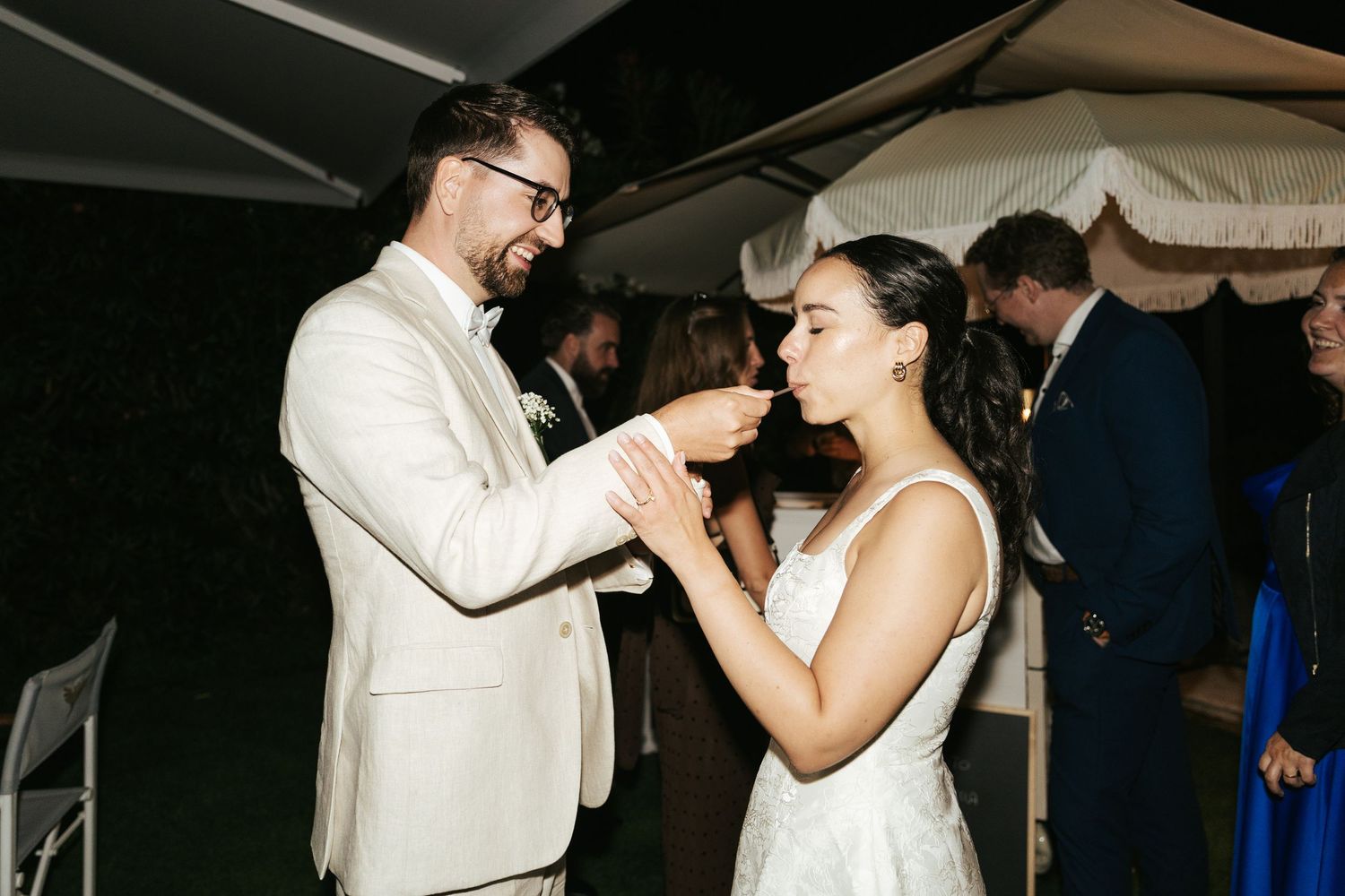 Wedding couple dancing together during nighttime reception celebration.
