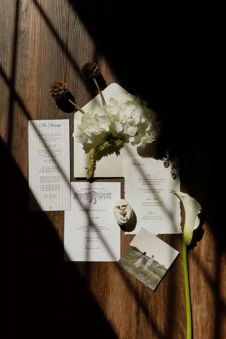 White flower and paper documents cast dramatic shadows on a rustic wooden surface in a series of artistic photographs.