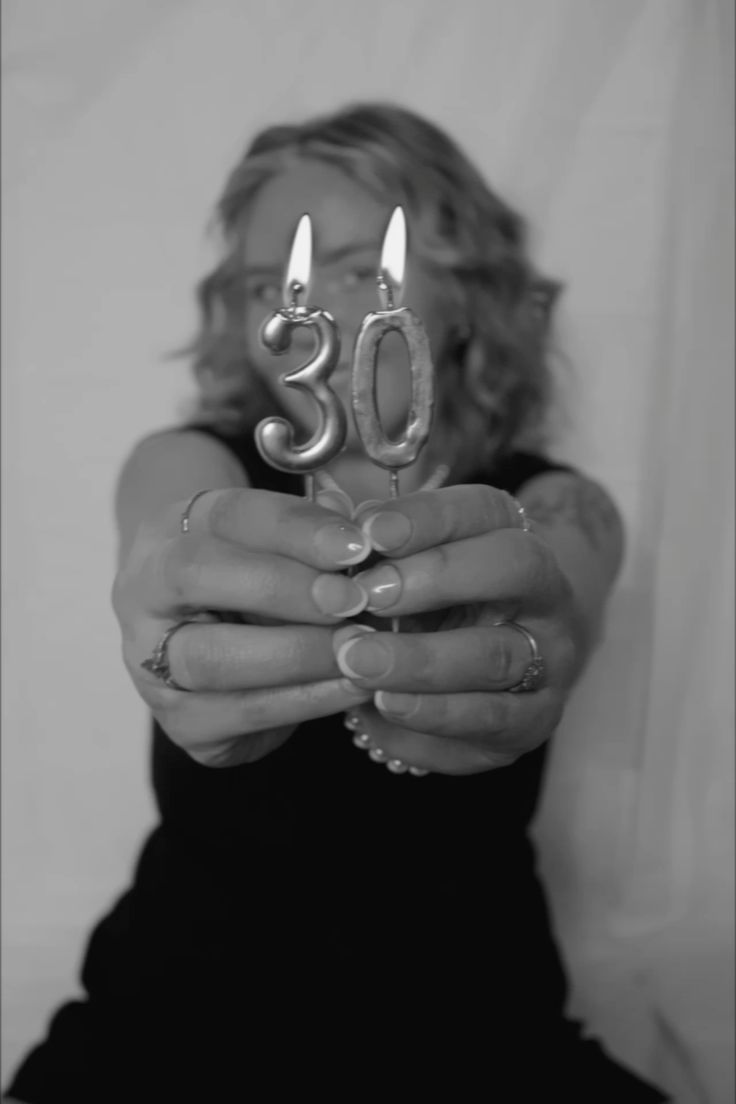 A series of black and white photos showing hands holding curved metallic jewelry pieces against a dark background.