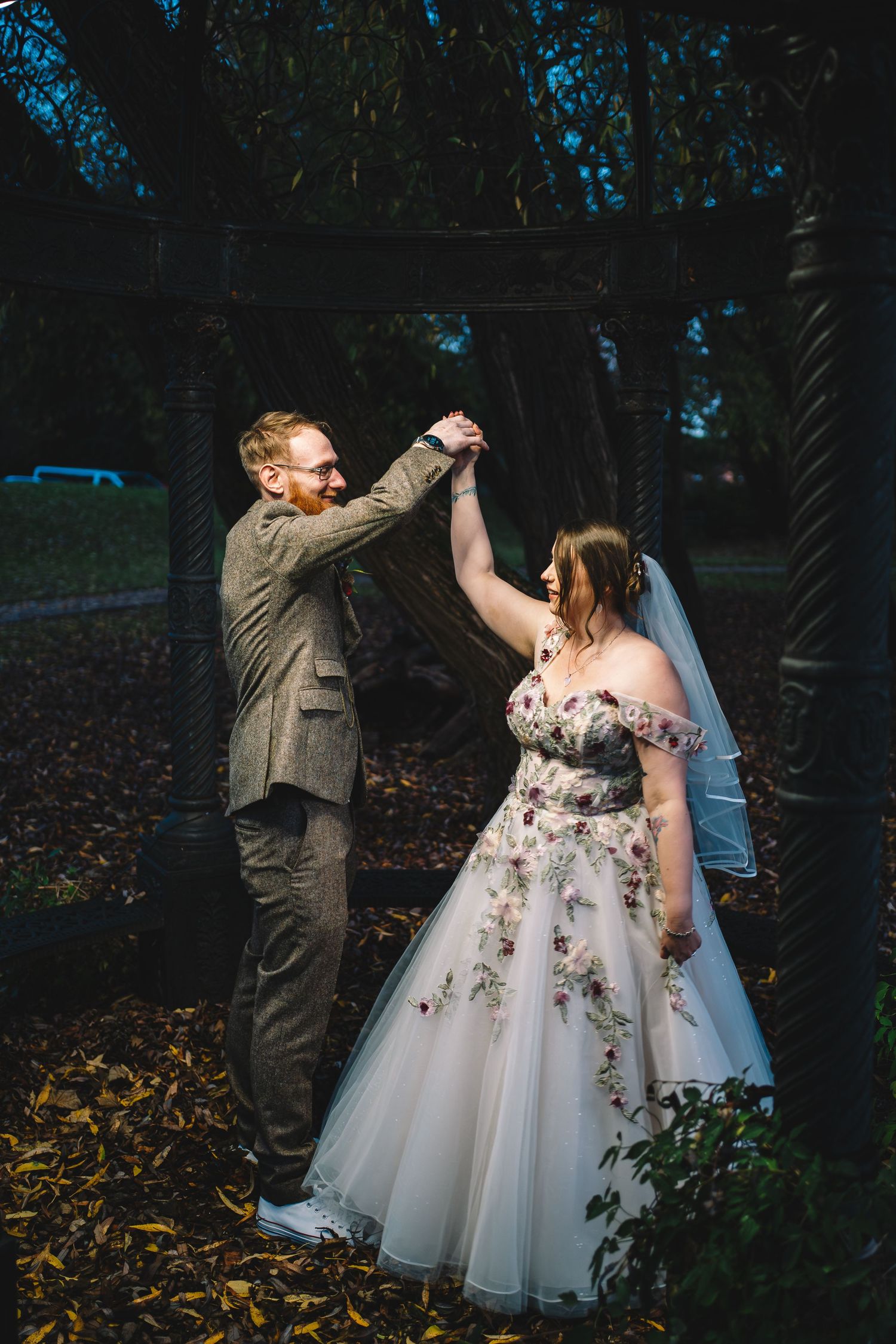 Bride and groom dancing together outdoors at night during a romantic wedding celebration.