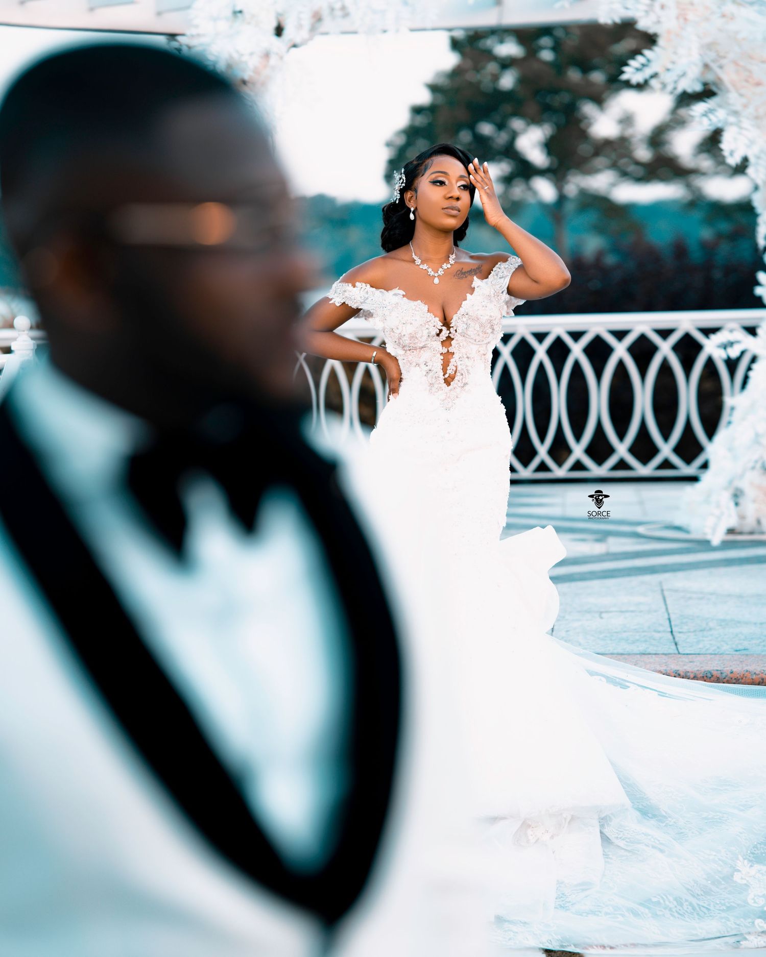 Creative wedding photography composition with selective focus and outdoor architectural elements.