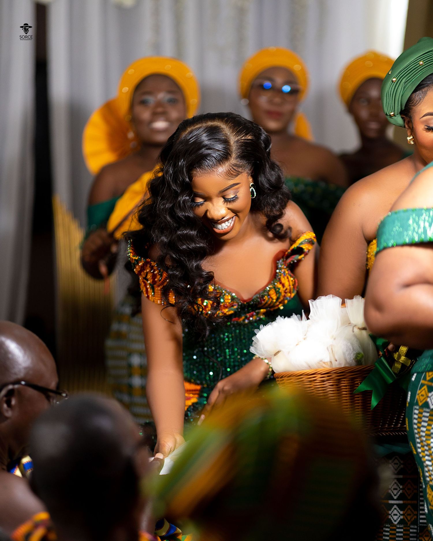 A group of guests in traditional African attire dancing and celebrating at a festive cultural event.