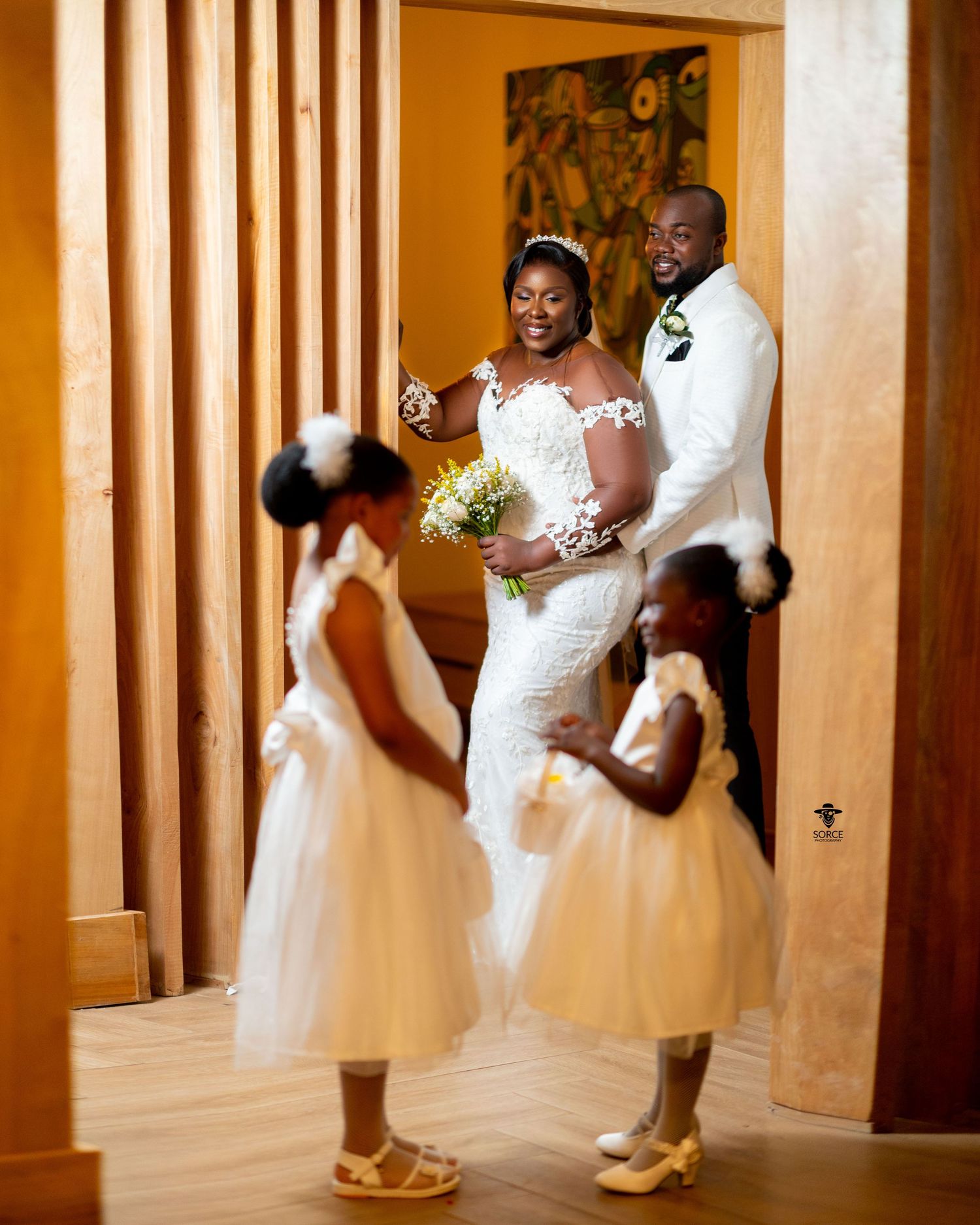 An elegant wedding photo series shows the couple in white attire dancing together in an ornate hall.