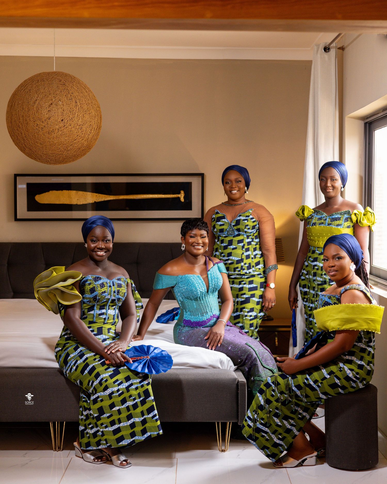 A six-panel photo sequence shows a woman in a vibrant African print dress posing on a modern couch with playful movements.