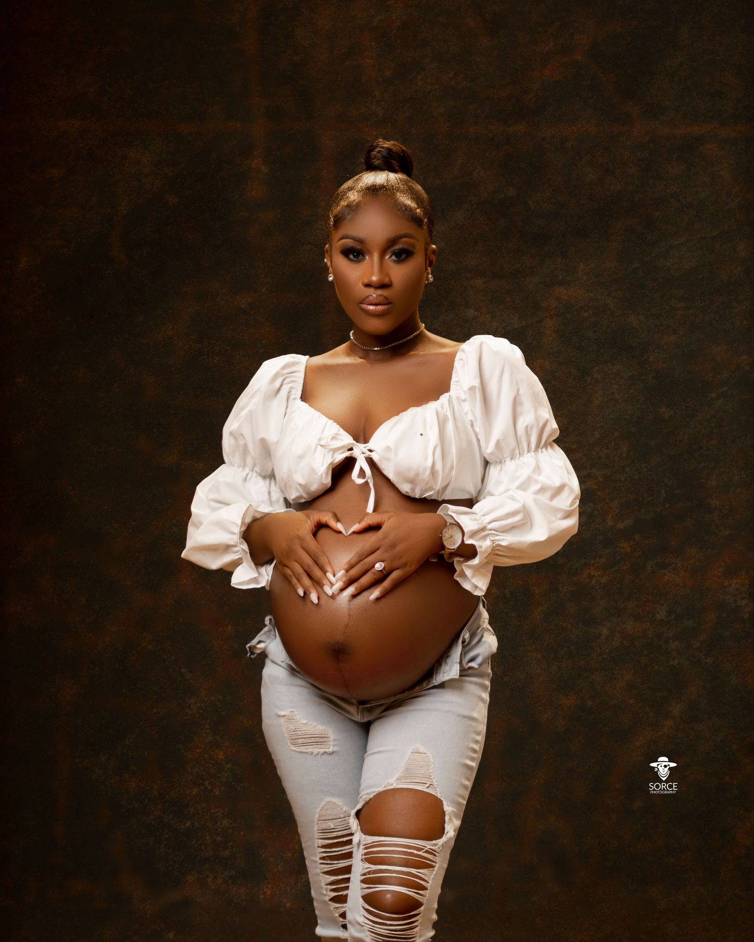 Artistic maternity photoshoot series showing someone wearing a white distressed outfit against a dark dramatic background.