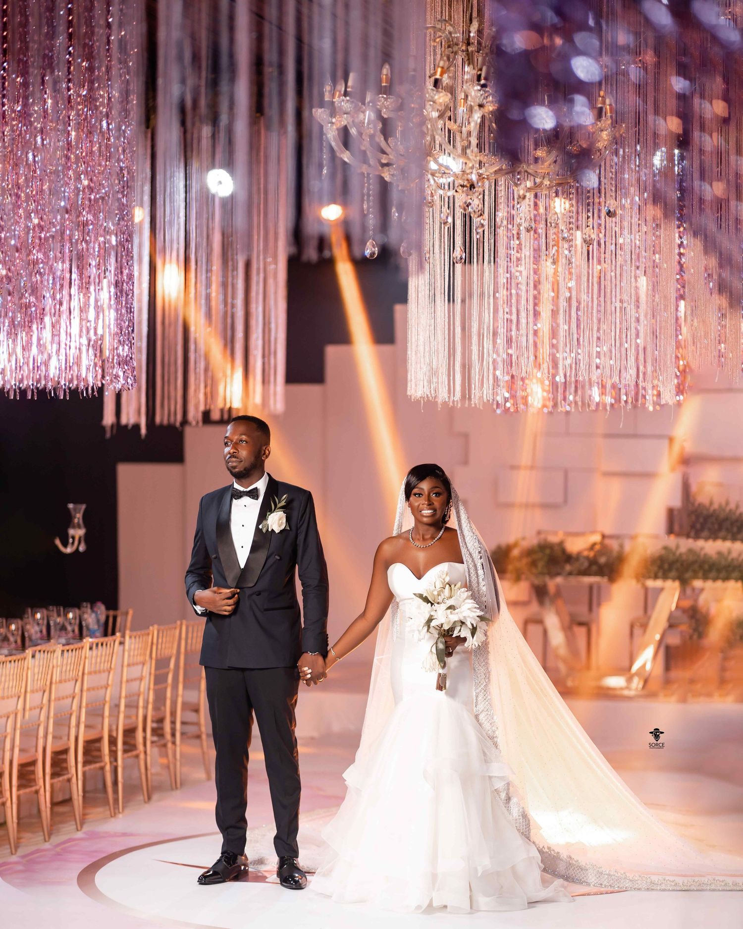An elegant wedding ceremony setup with cascading crystal chandeliers and soft lighting creating a romantic atmosphere.