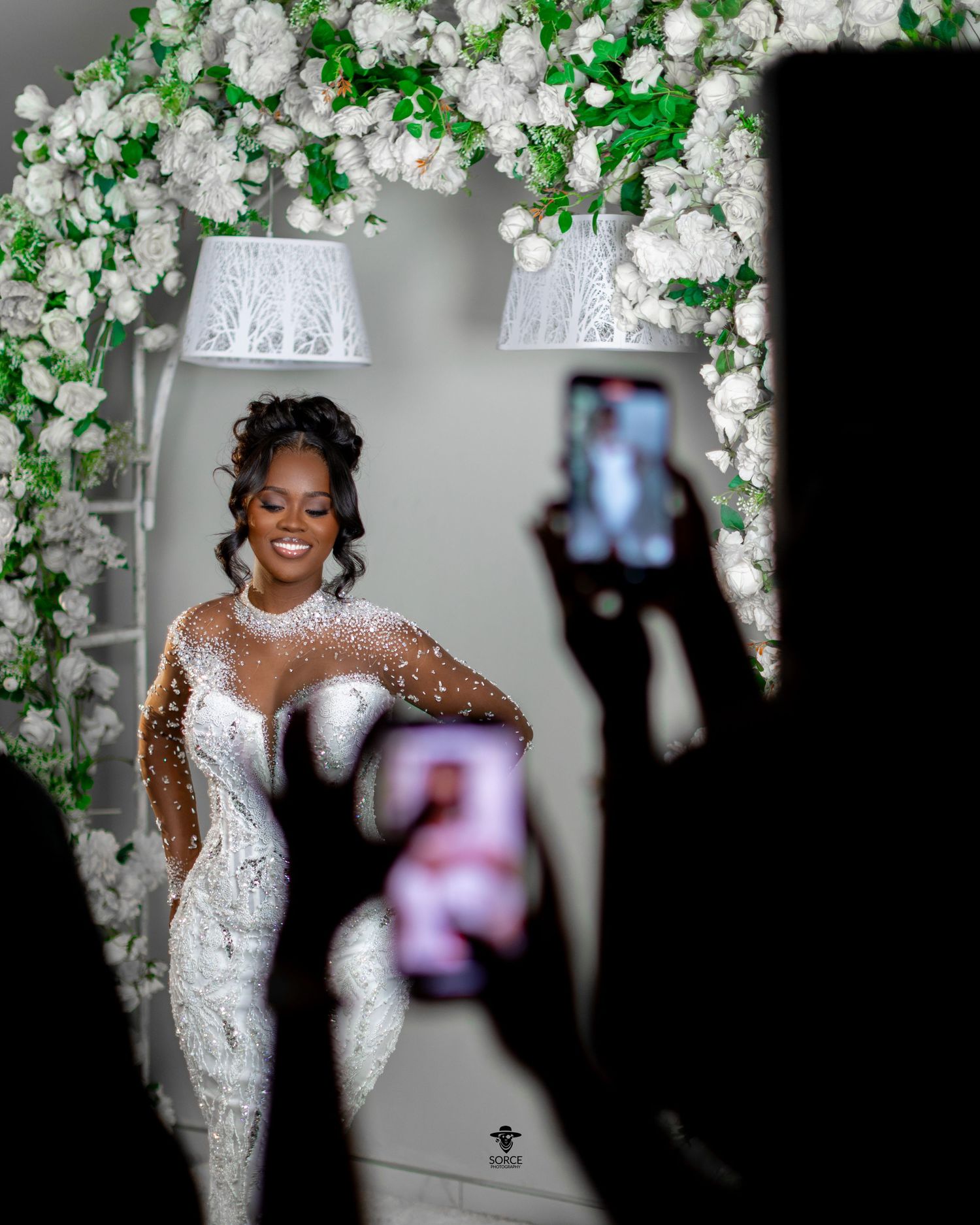 Elegant wedding celebration with white floral arrangements and greenery decorating the intimate indoor venue.
