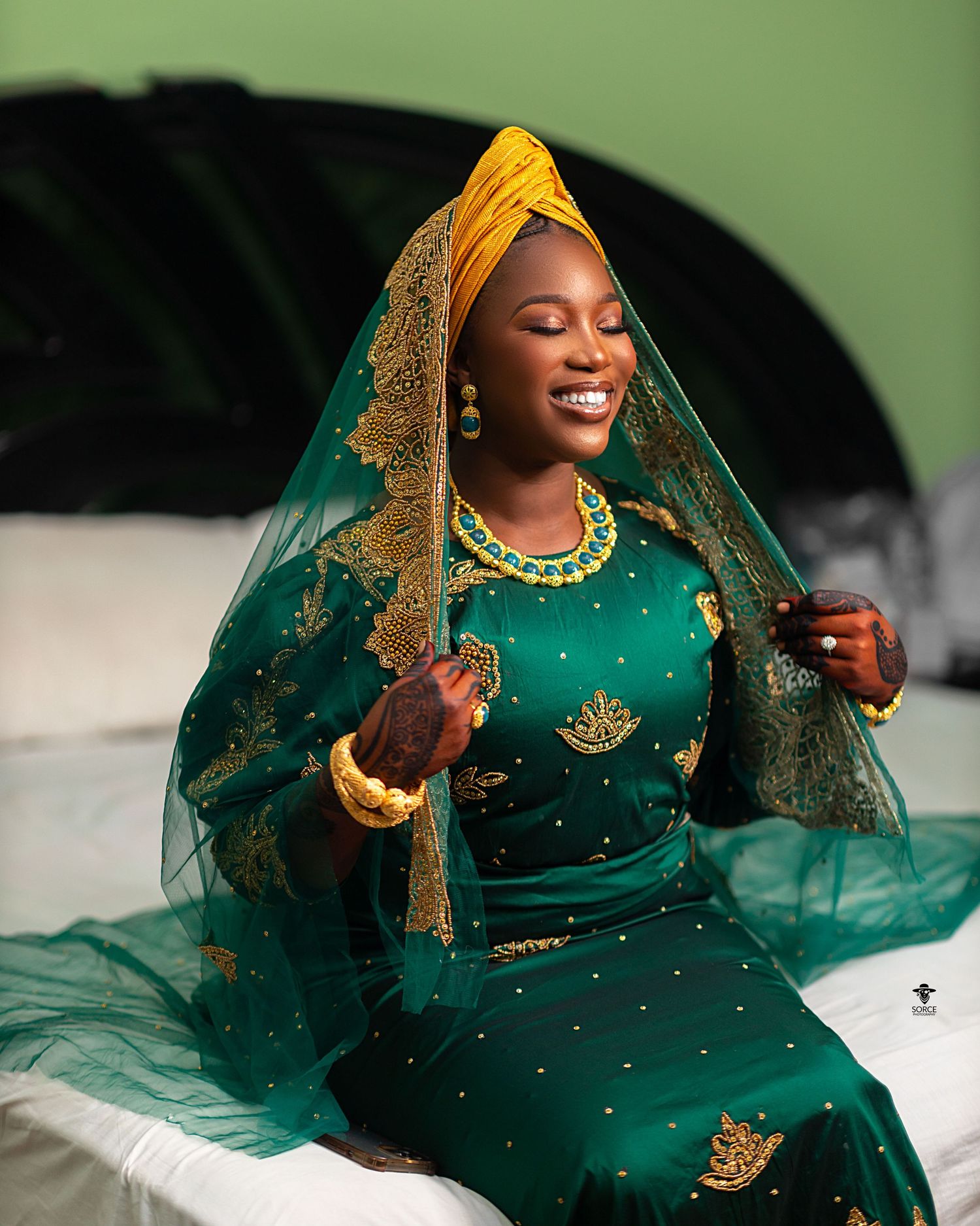 Traditional Nigerian Islamic bridal portrait series in emerald green and gold attire with flowing veil against natural backdrop.