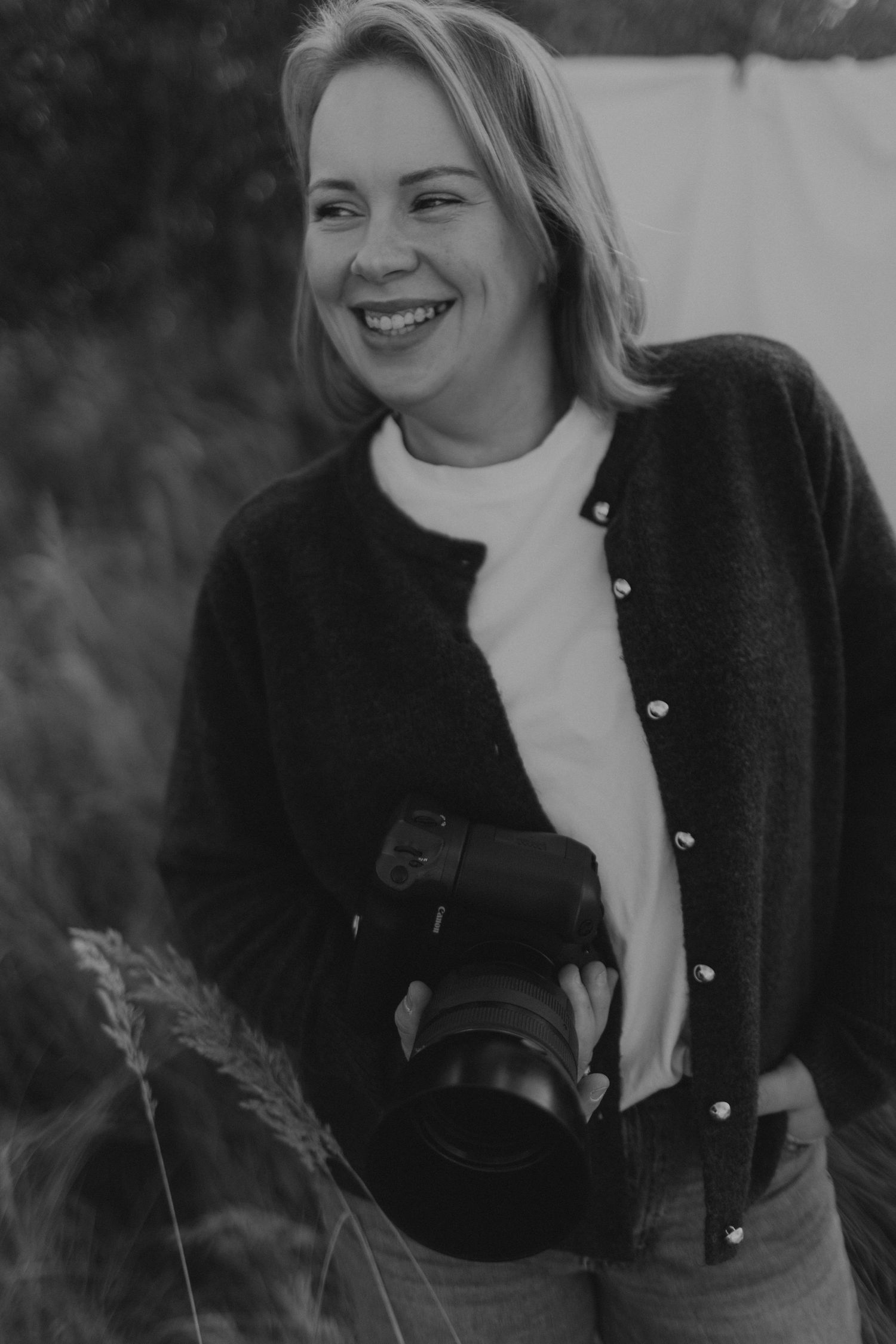 Black and white portrait series showing joyful expressions and natural laughter in an outdoor setting.