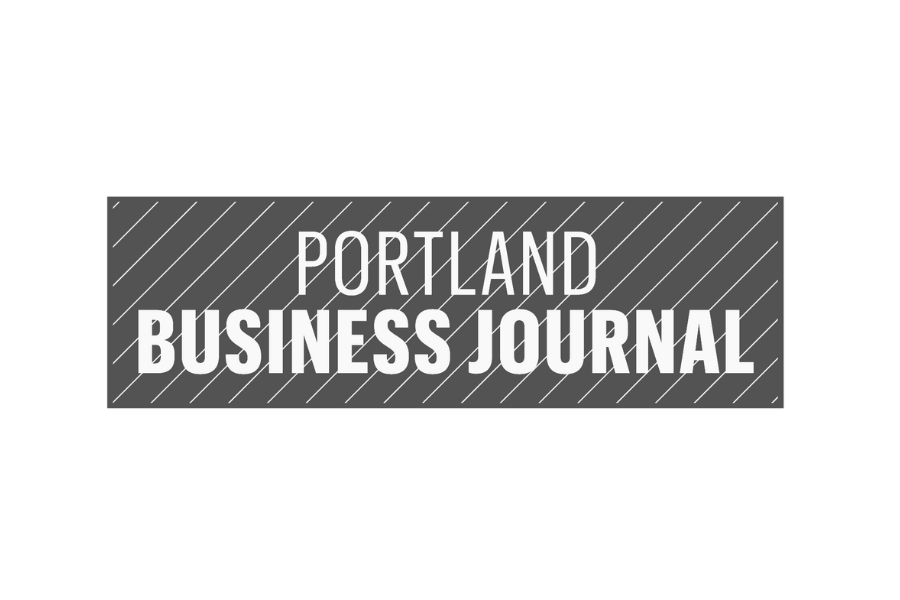 Portland Business Journal logo in white text on a gray striped background.