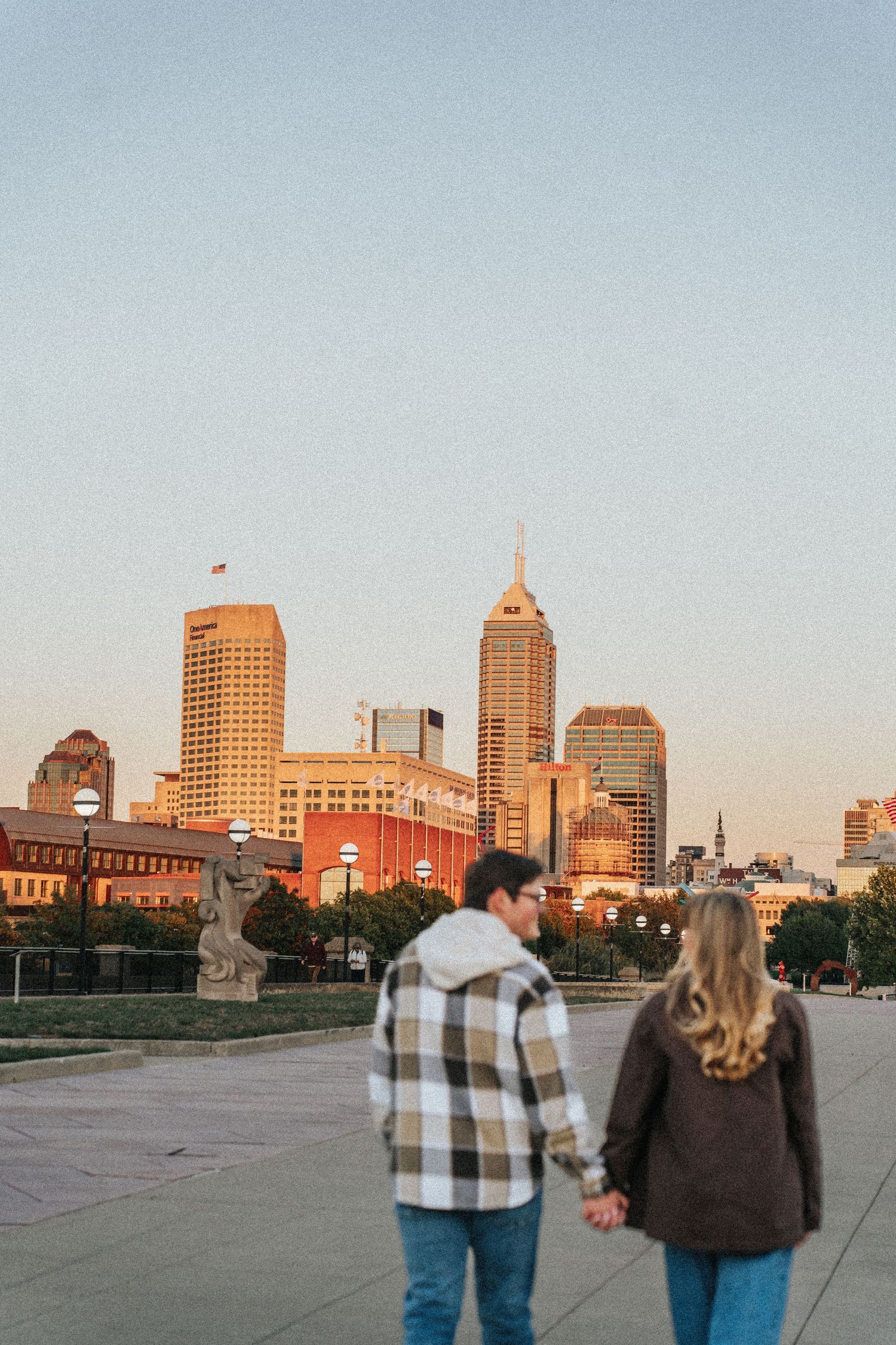 A couple admires the Indianapolis skyline at sunset from White River State Park.