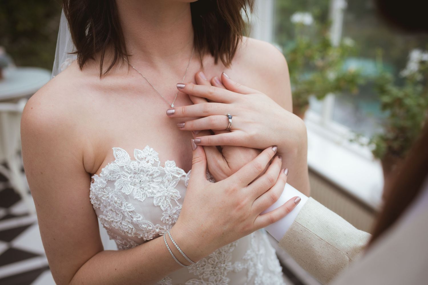 Close up of grooms hand on brides chest and heart at Kinsale wedding photographed by Irish Wedding photographer Paul Cowhig