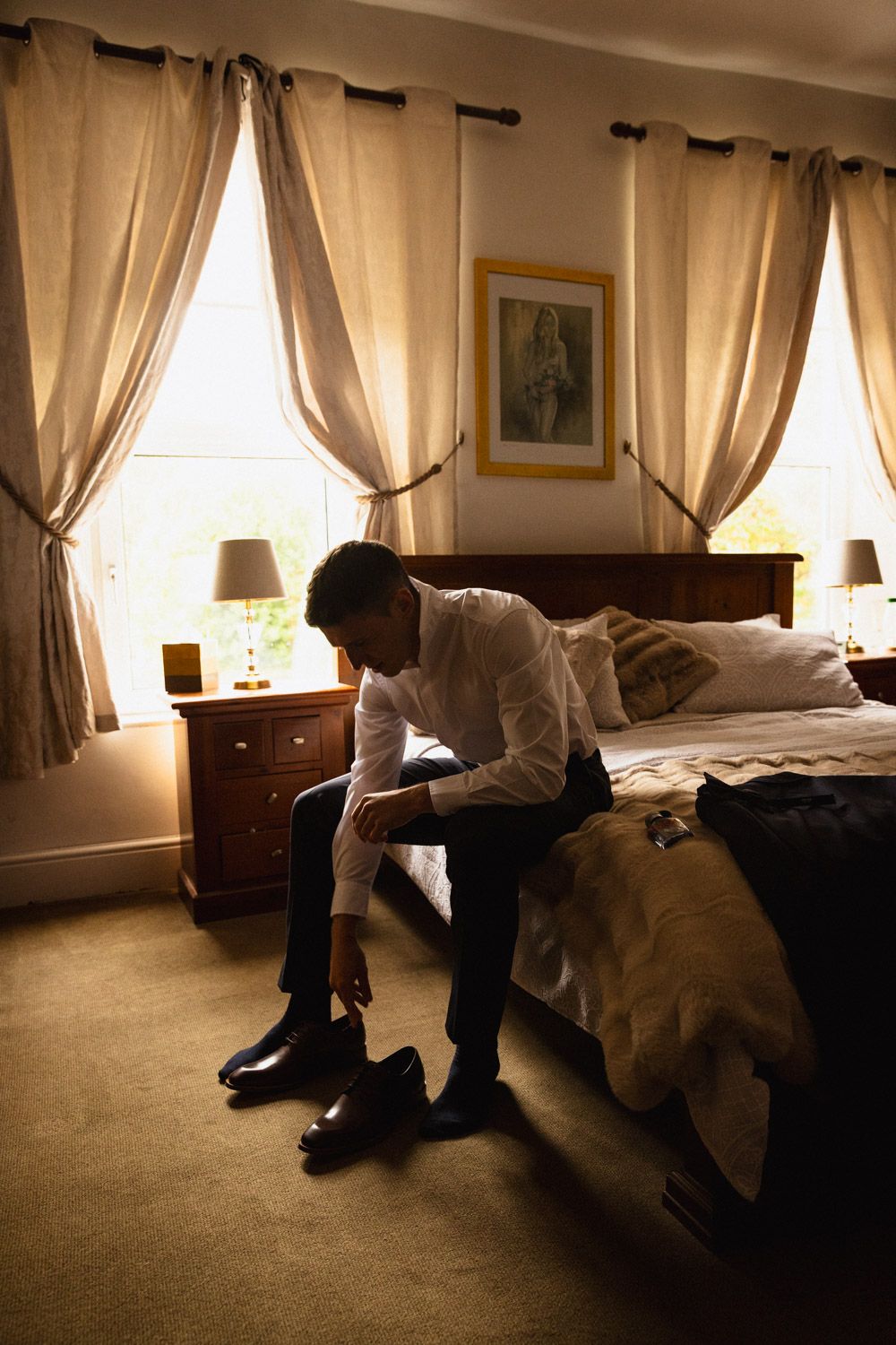 Groom putting on his shoes on the morning of his wedding in Dublin, Ireland