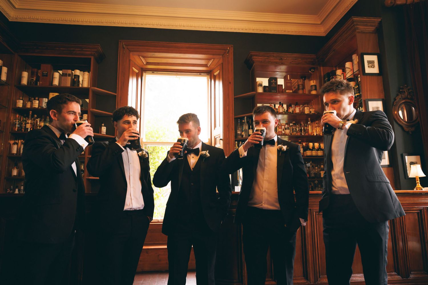 Groom and Groomsmen posing for photo while drinking guinness at bar in Wicklow wedding