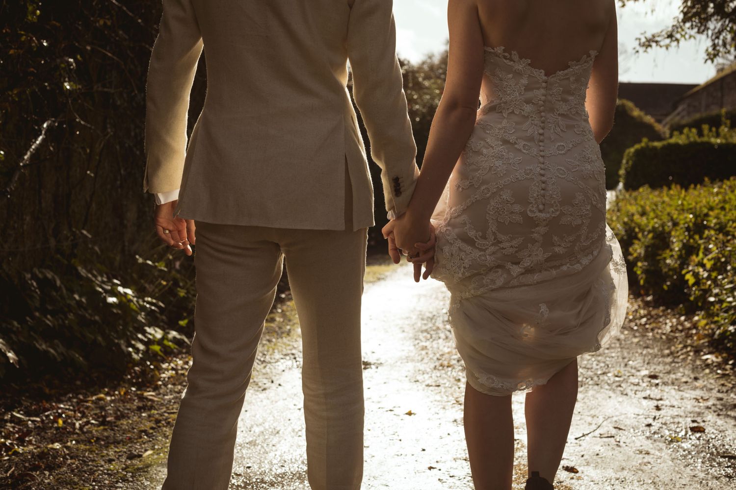 Bride and groom holding hands at path near Kinsale wedding photographed by Paul Cowhig