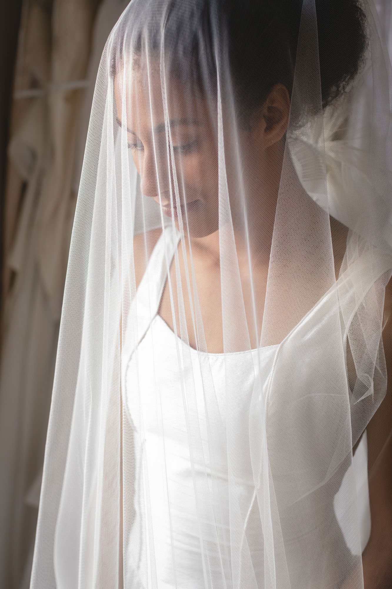 Bride standing with veil over face before wedding