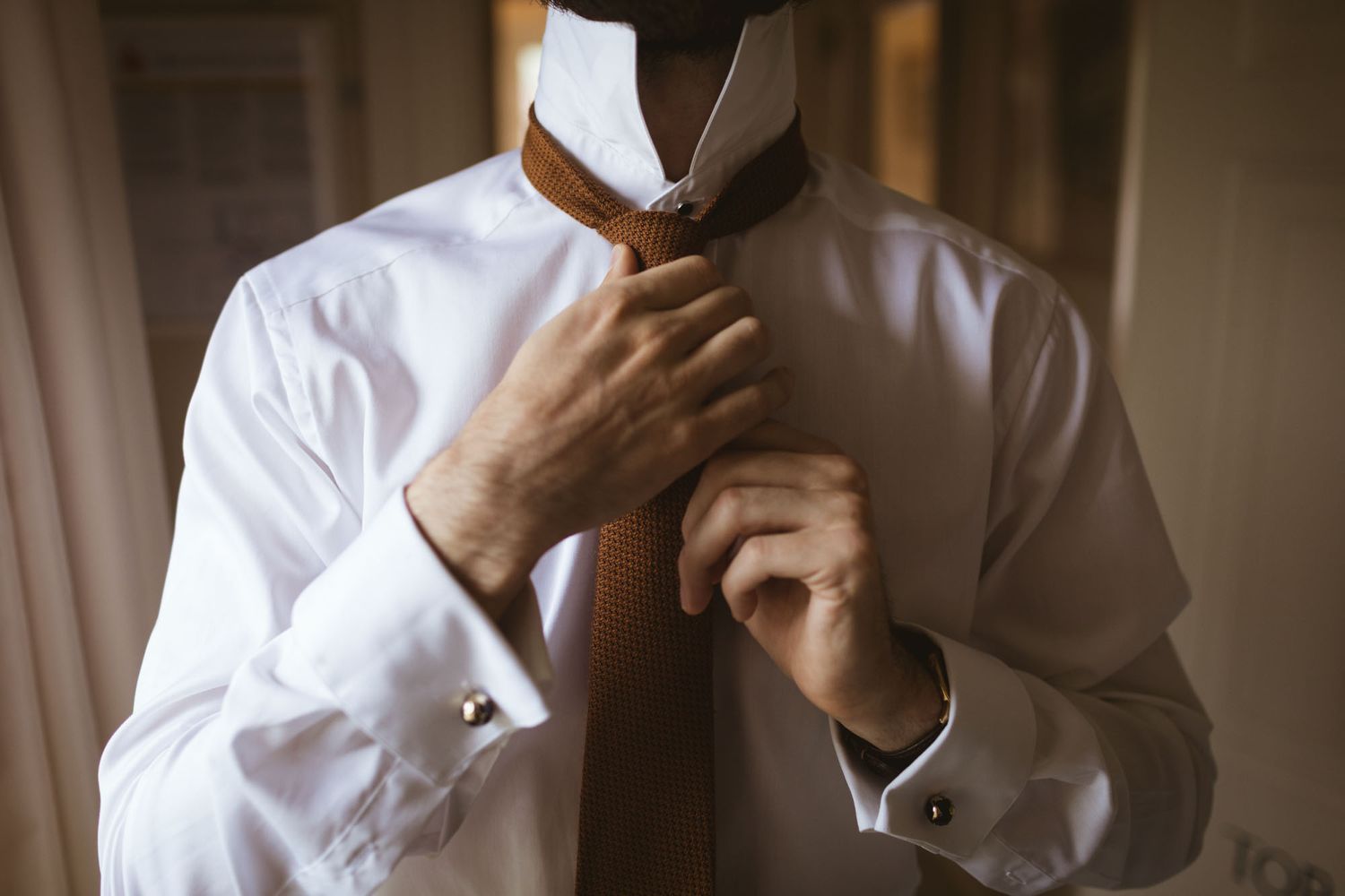 Close up of Groom getting ready at Ballymaloe house in Cork,