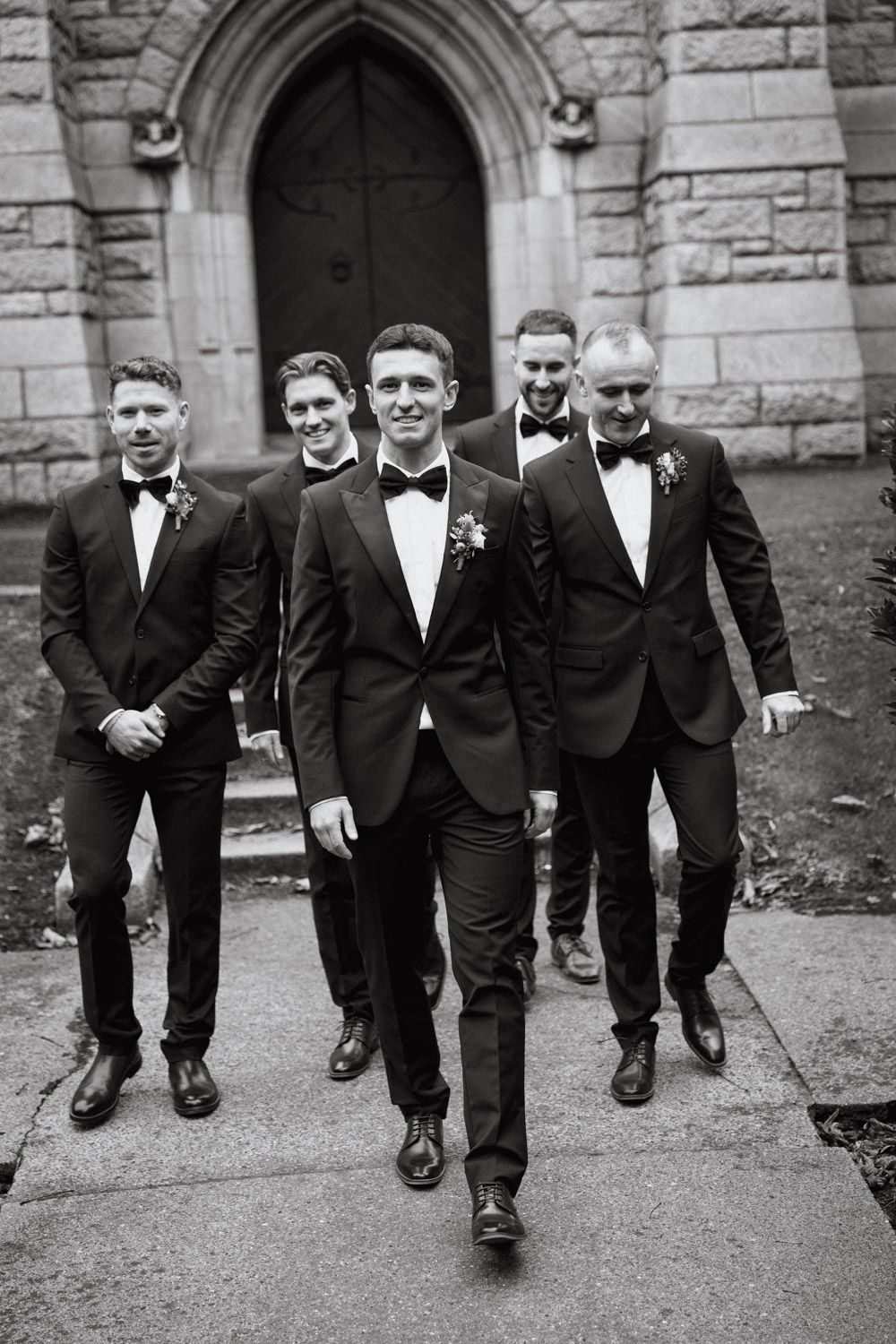 Candid moment of groom and groomsmen walking to ceremony  before wedding in Dublin