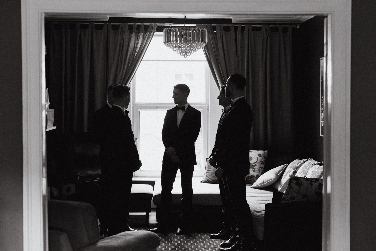 Groom and groomsmen sharing a relaxed moment before the wedding by Paul Cowhig Wedding Photographer