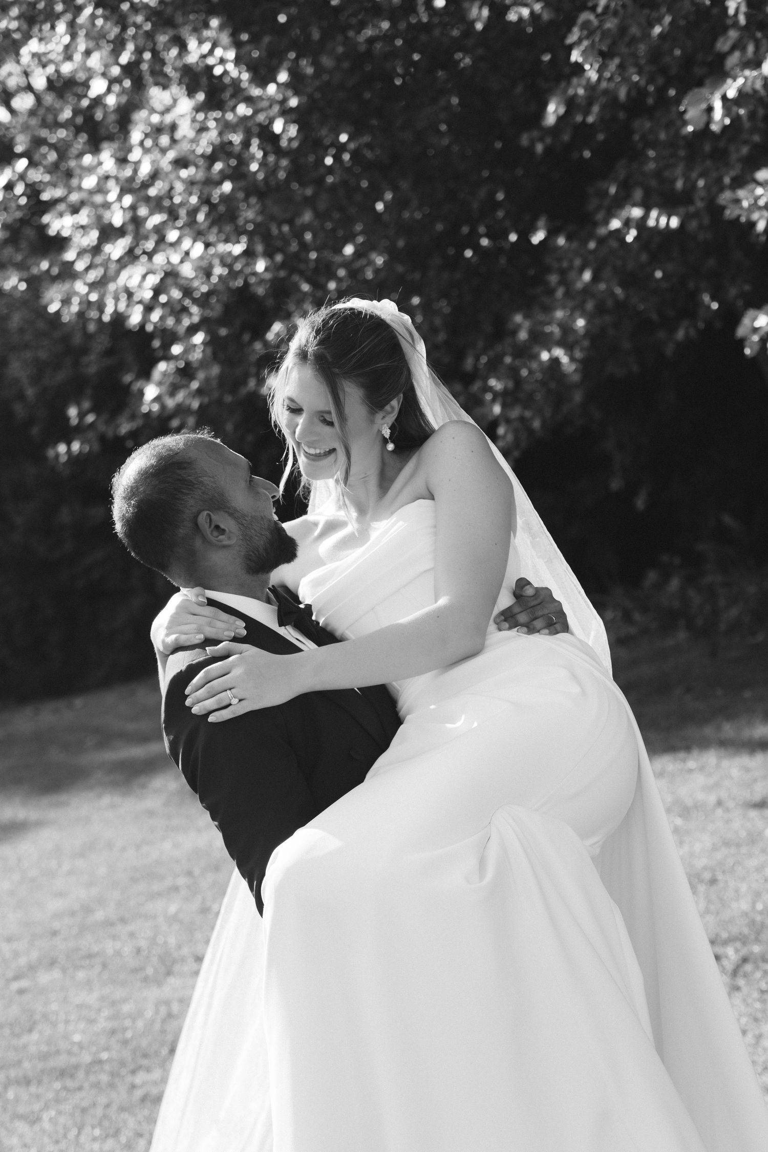 A romantic black and white wedding photo sequence shows a couple sharing a tender kiss in an outdoor garden setting.