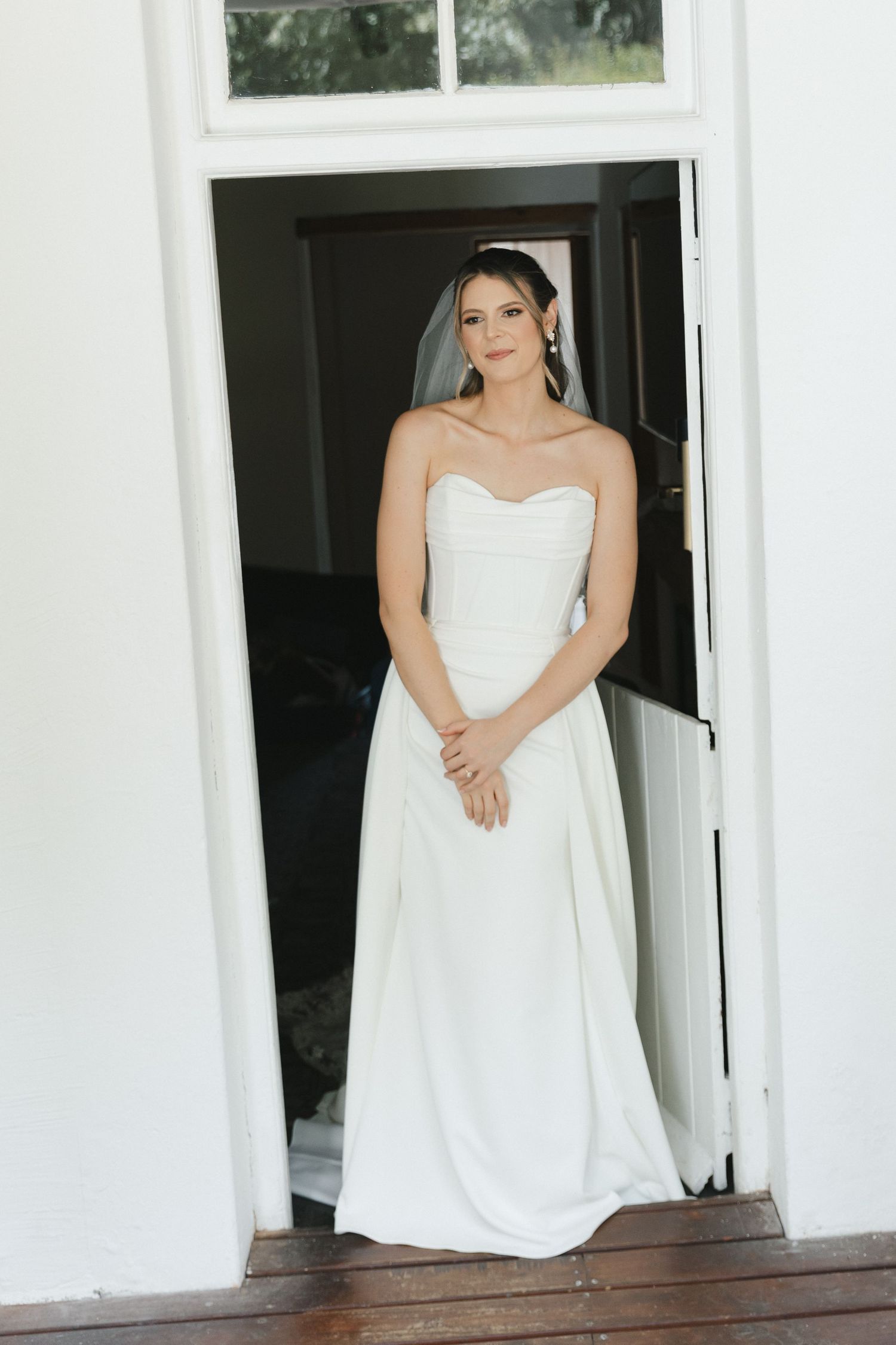 Three elegant white bridal portraits showing someone in a strapless wedding gown posing on a porch with white columns.