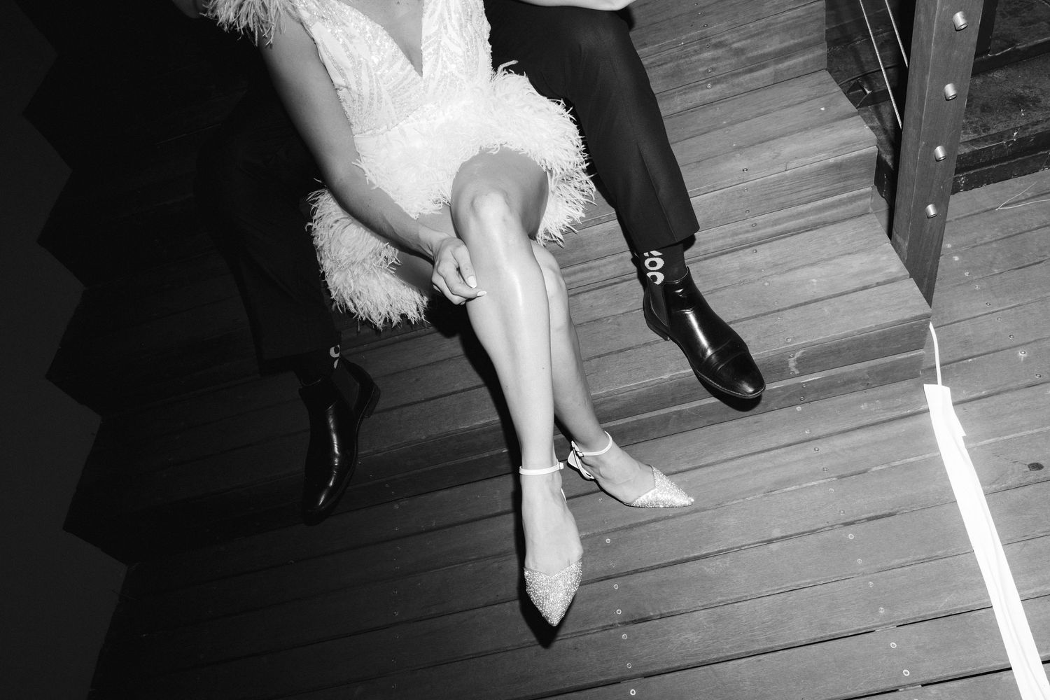 Black and white high heels lined up in a row on a wooden floor showing different angles and perspectives.