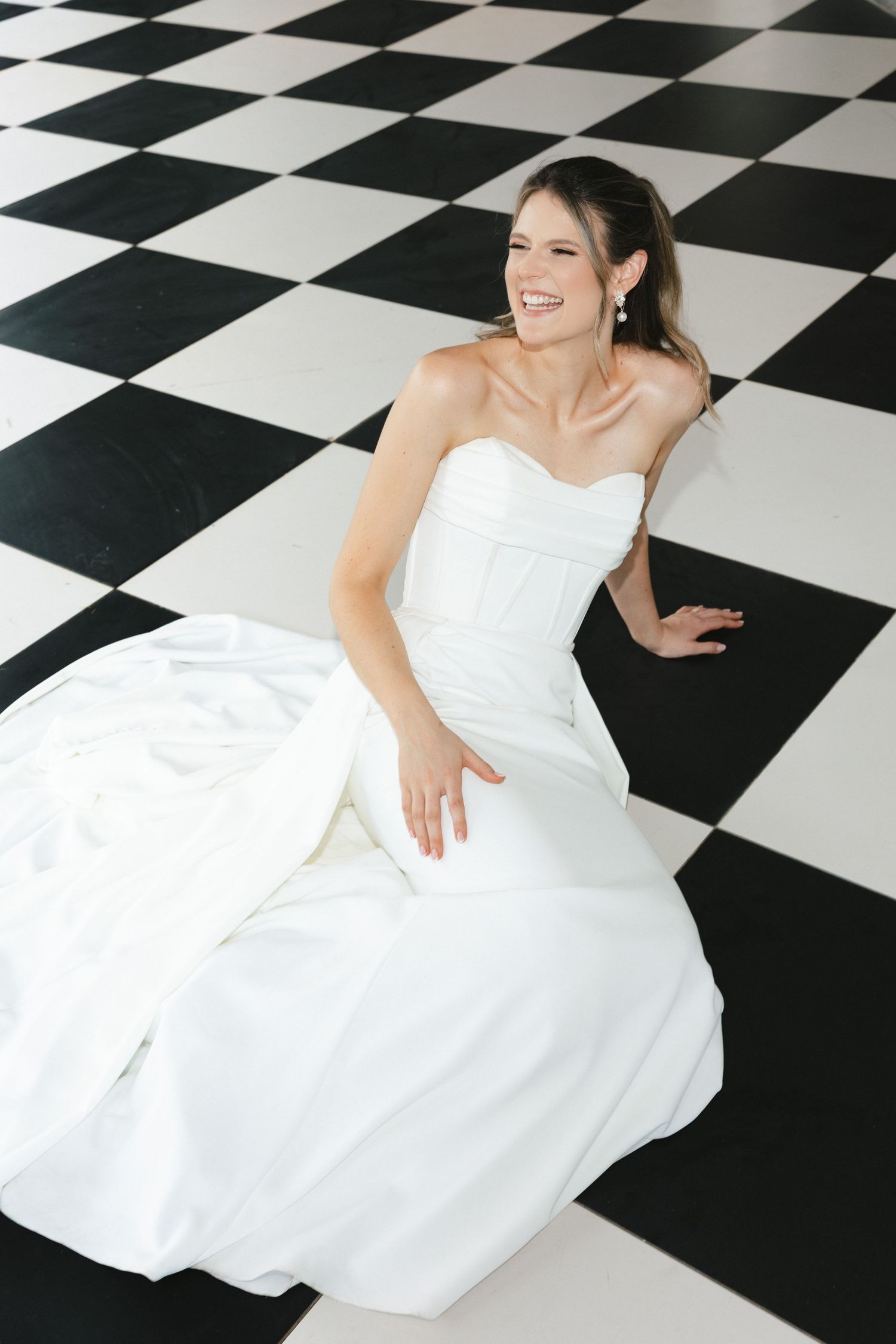 A person in a white wedding dress poses gracefully on a black and white checkered floor in a photo series.