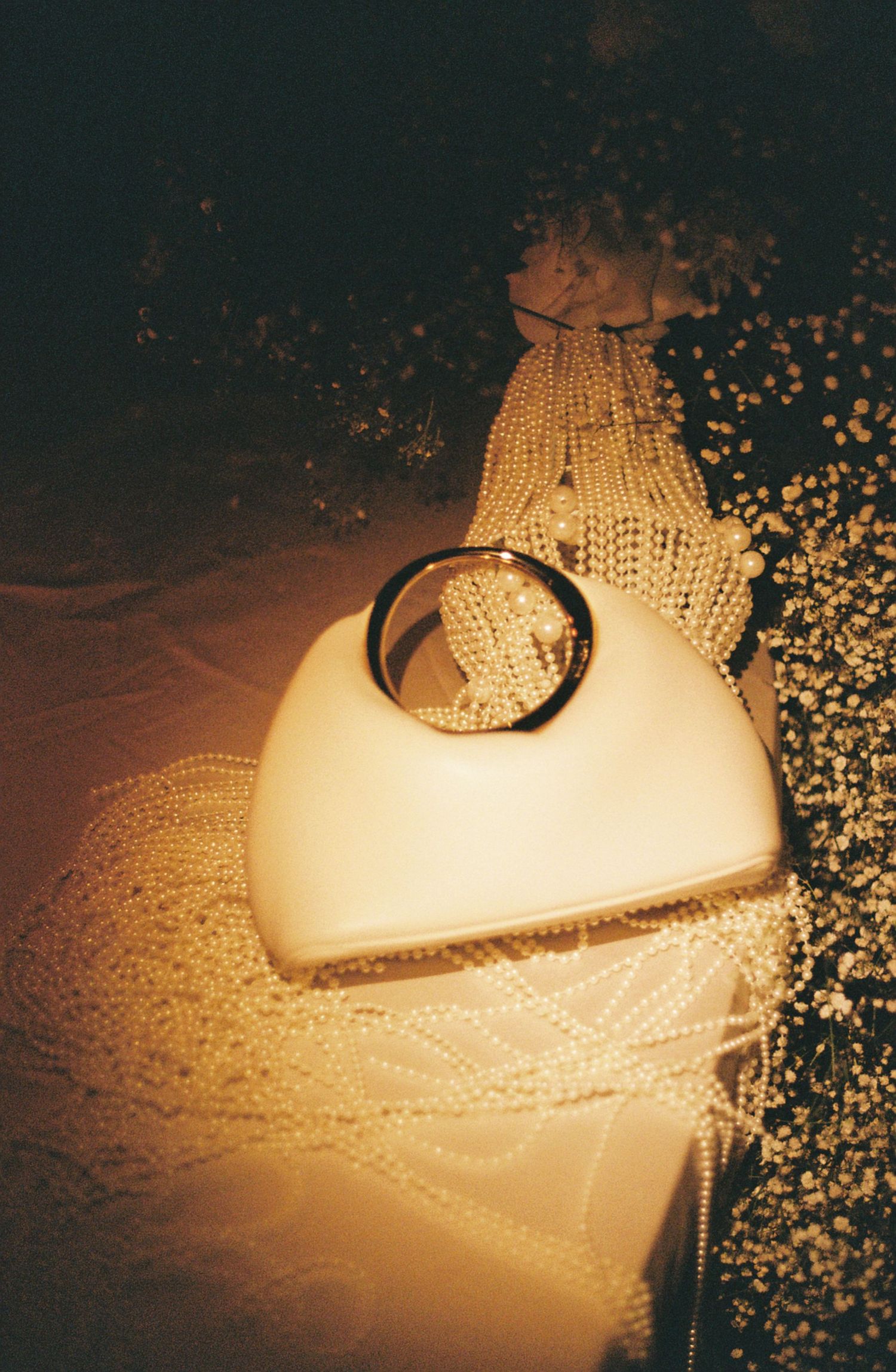 A wedding dress illuminated by warm light creates an ethereal glow with scattered bokeh effects.