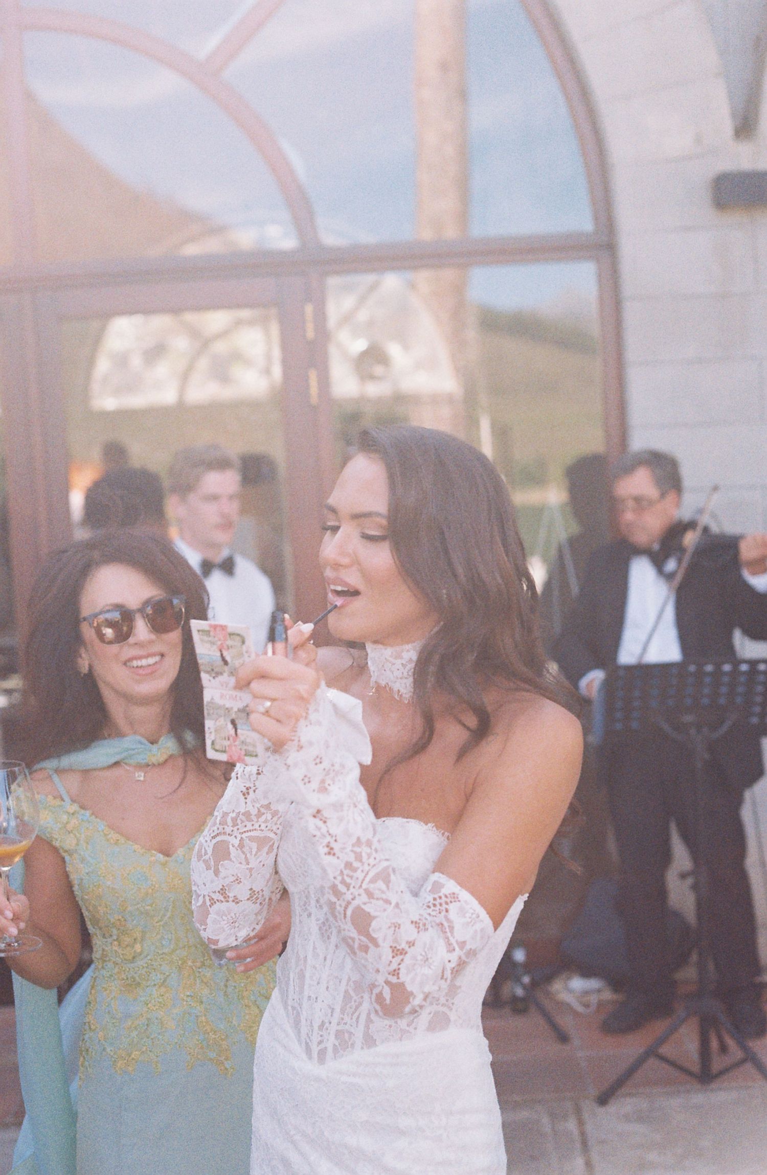 Wedding celebration with guests and musicians in an outdoor venue setting.