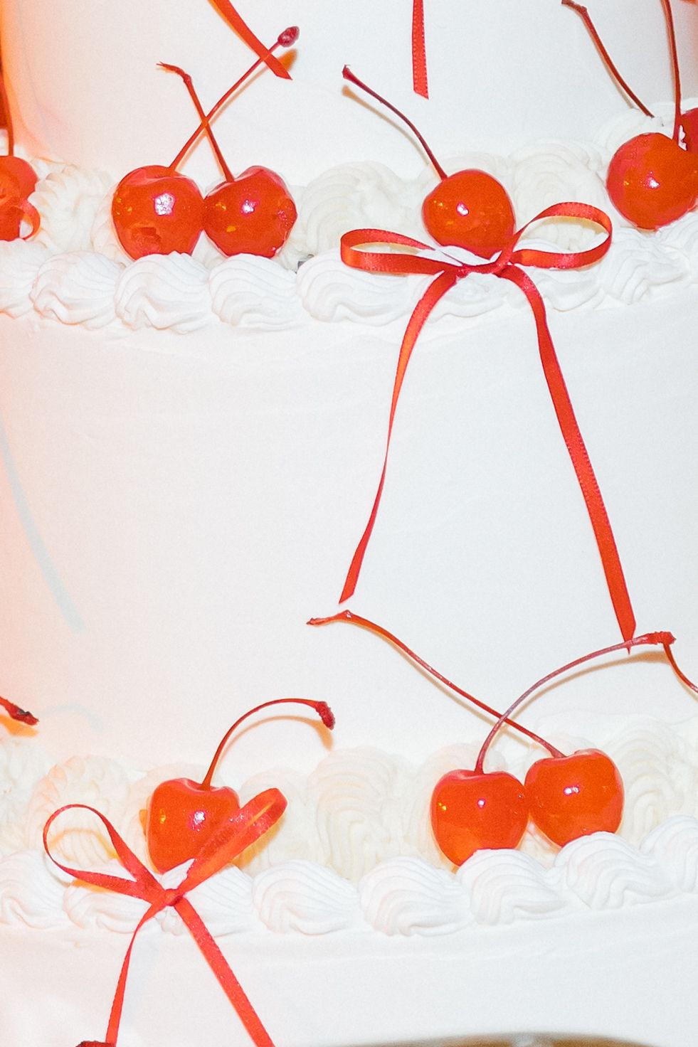 Red heart shapes with bows create a delicate repeating pattern on a white background.