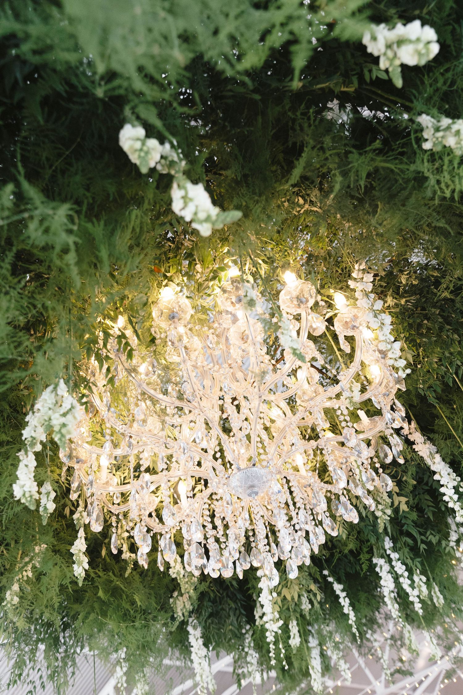 Delicate white hanging floral decorations create an ethereal ceiling display with soft lighting effects.