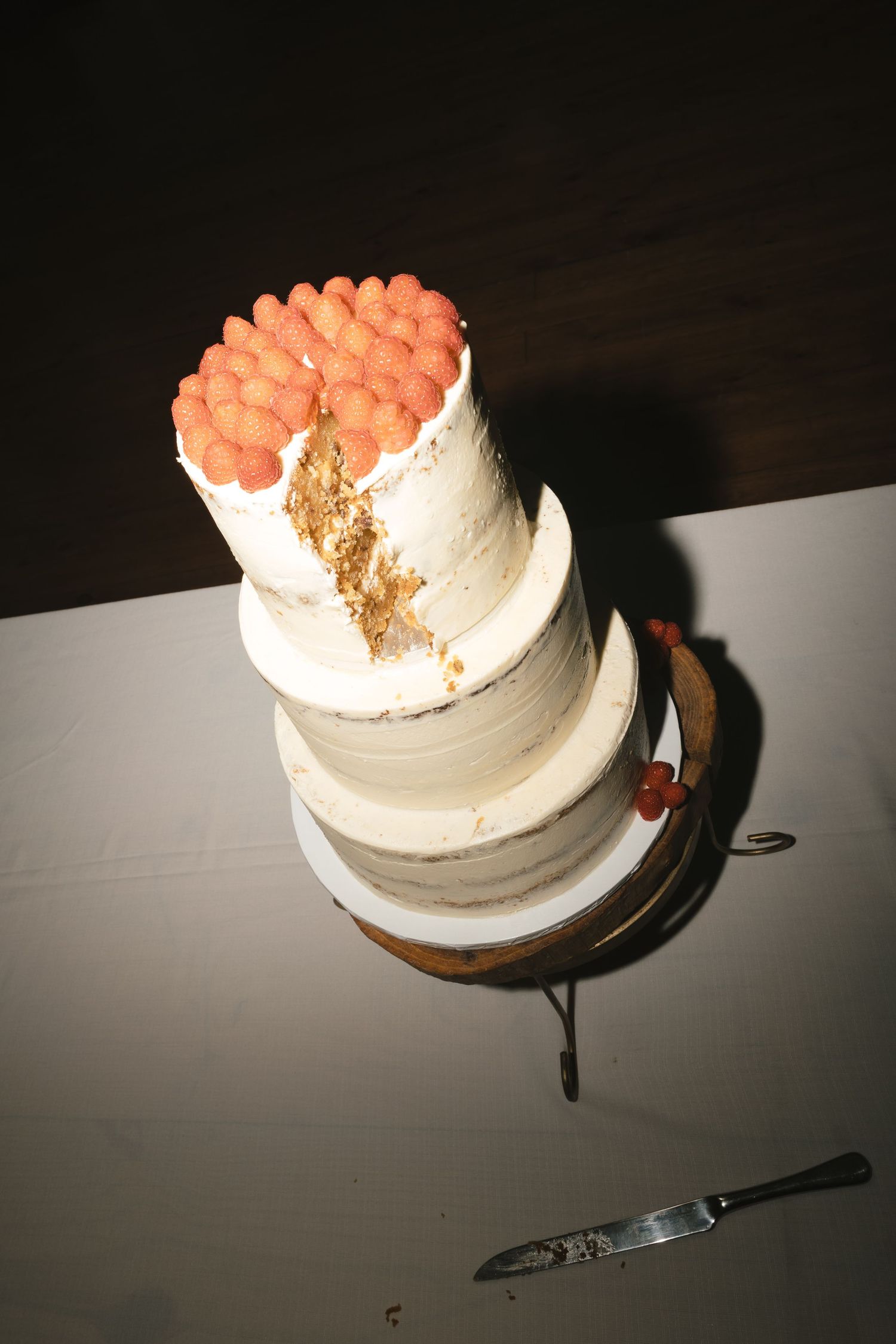 A sequence of photos showing a white frosted cake being cut into slices on a dark surface.