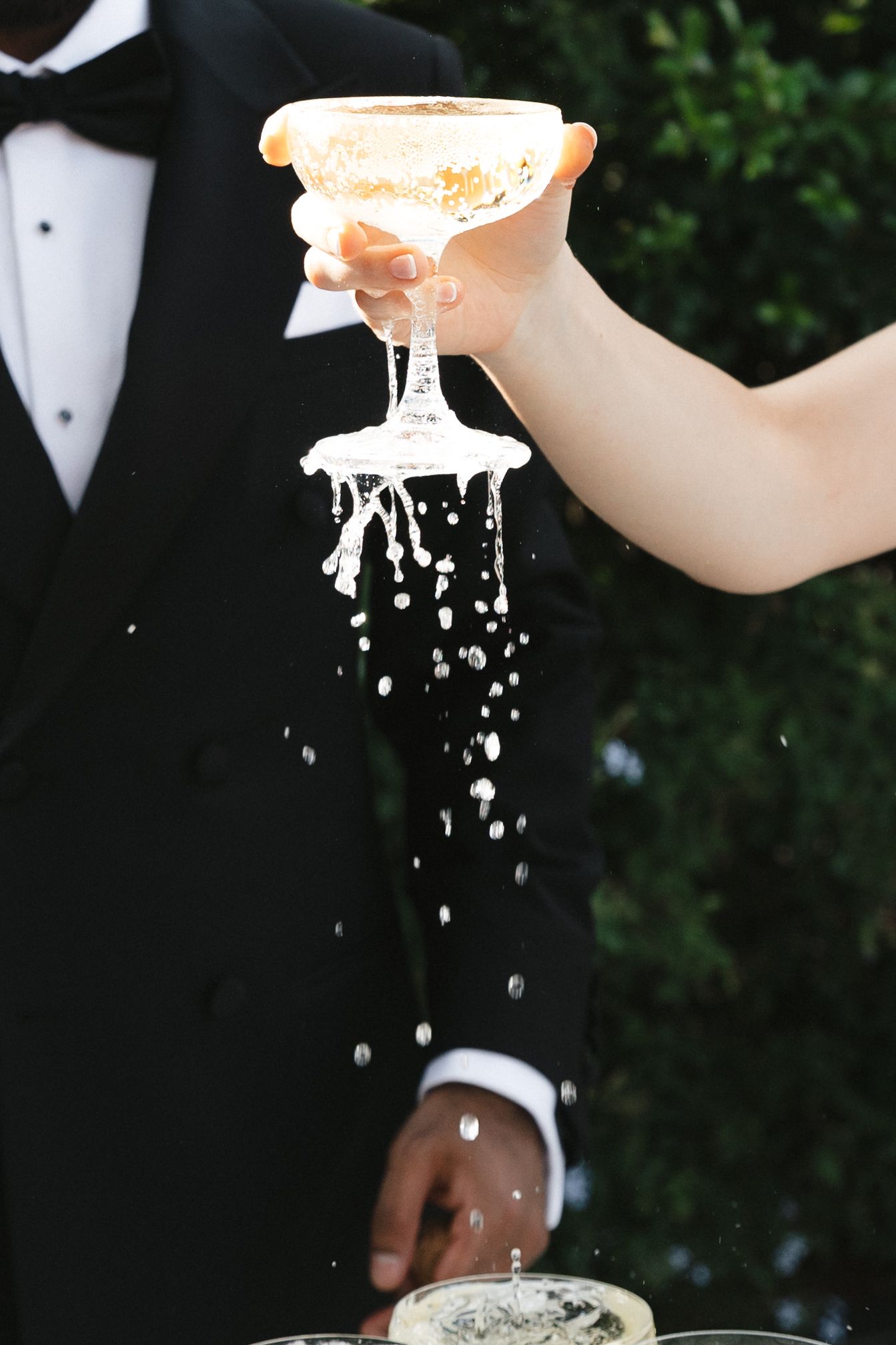 A sequence of champagne being poured into a glass with splashing and bubbles against a dark background.