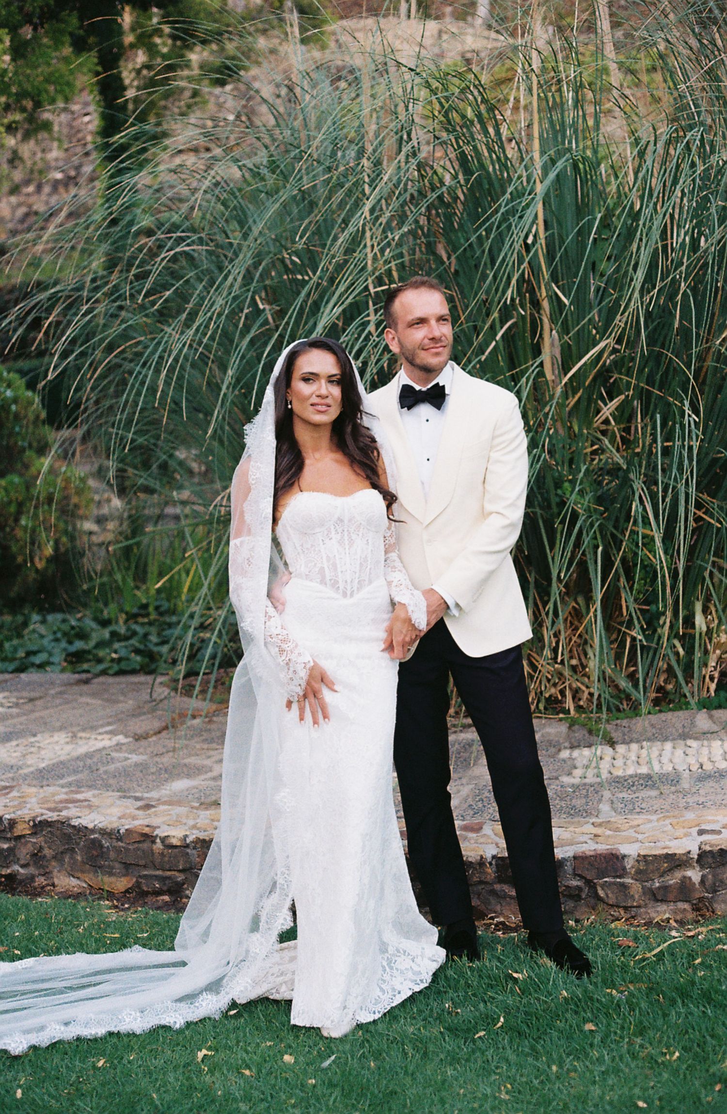 A series of romantic wedding photos featuring a couple posing against tall ornamental grasses in a garden setting.