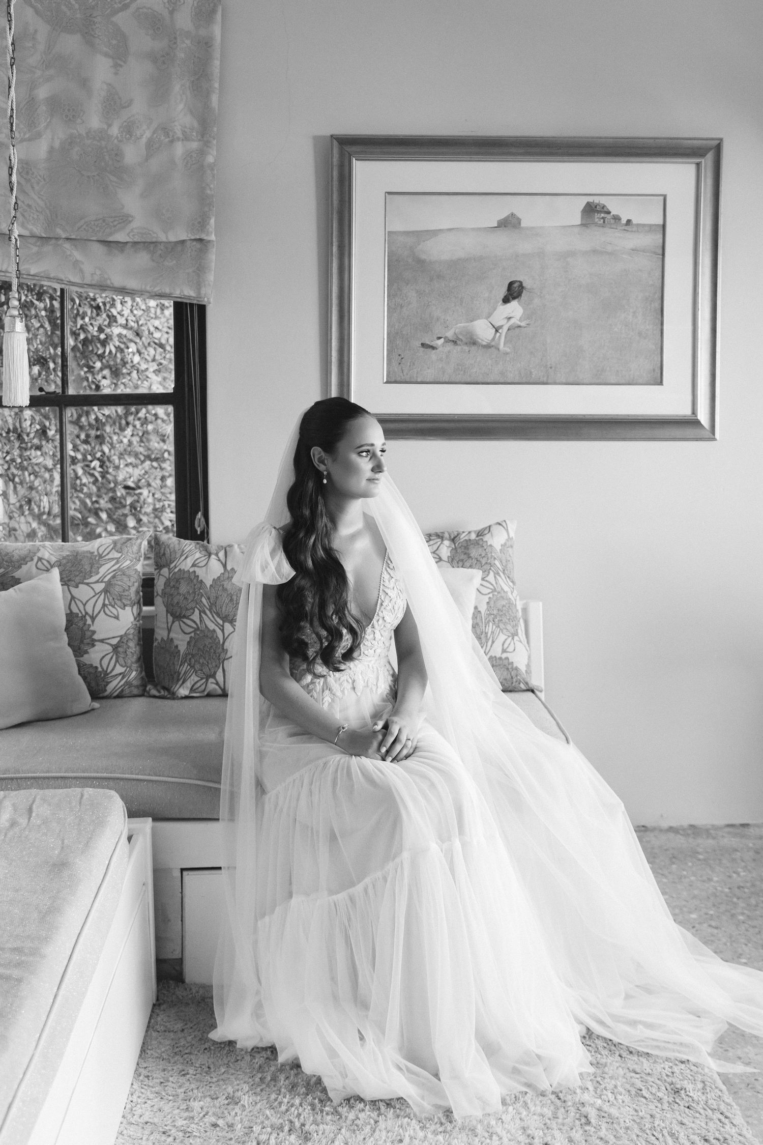 Elegant bridal portraits in a flowing white gown against neutral walls with framed artwork.