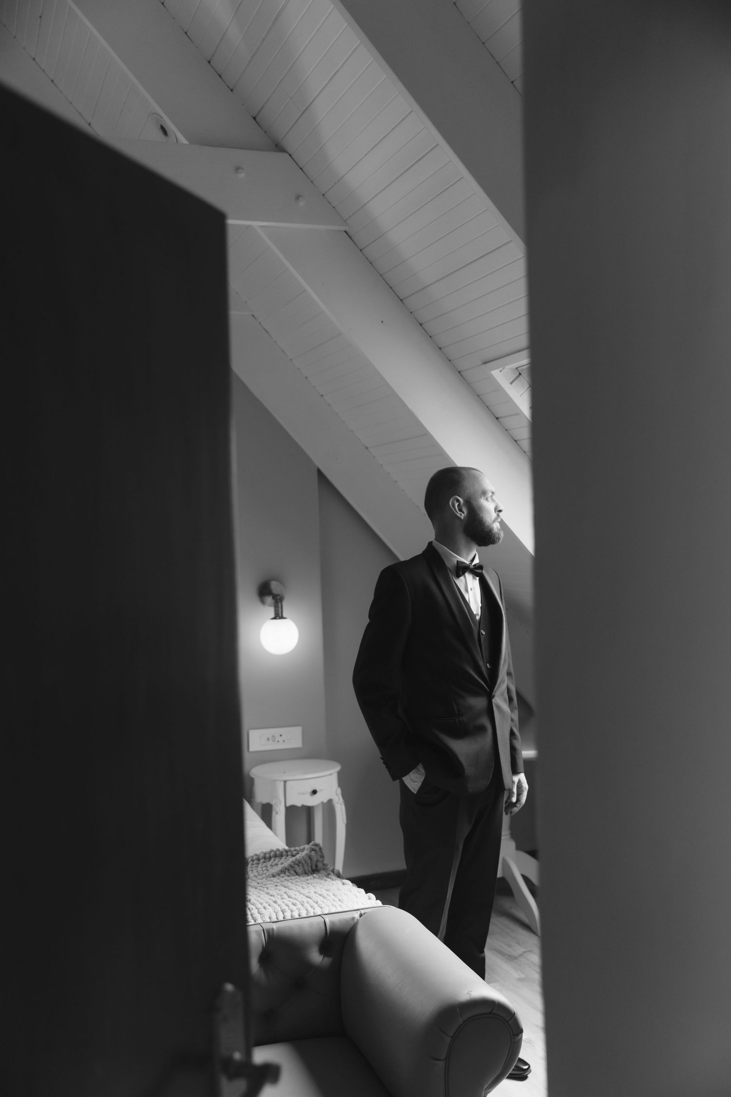 A series of black and white photographs showing a person in formal attire walking through a minimalist hallway space.