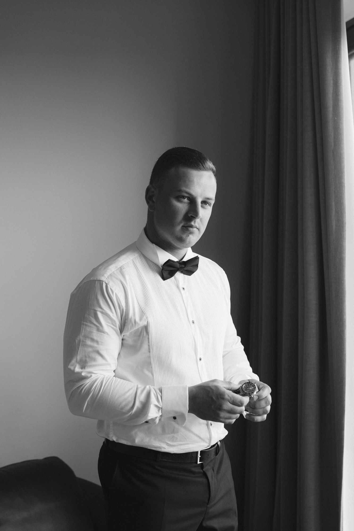 Black and white photo series showing a person in formal attire adjusting their bow tie while getting dressed.