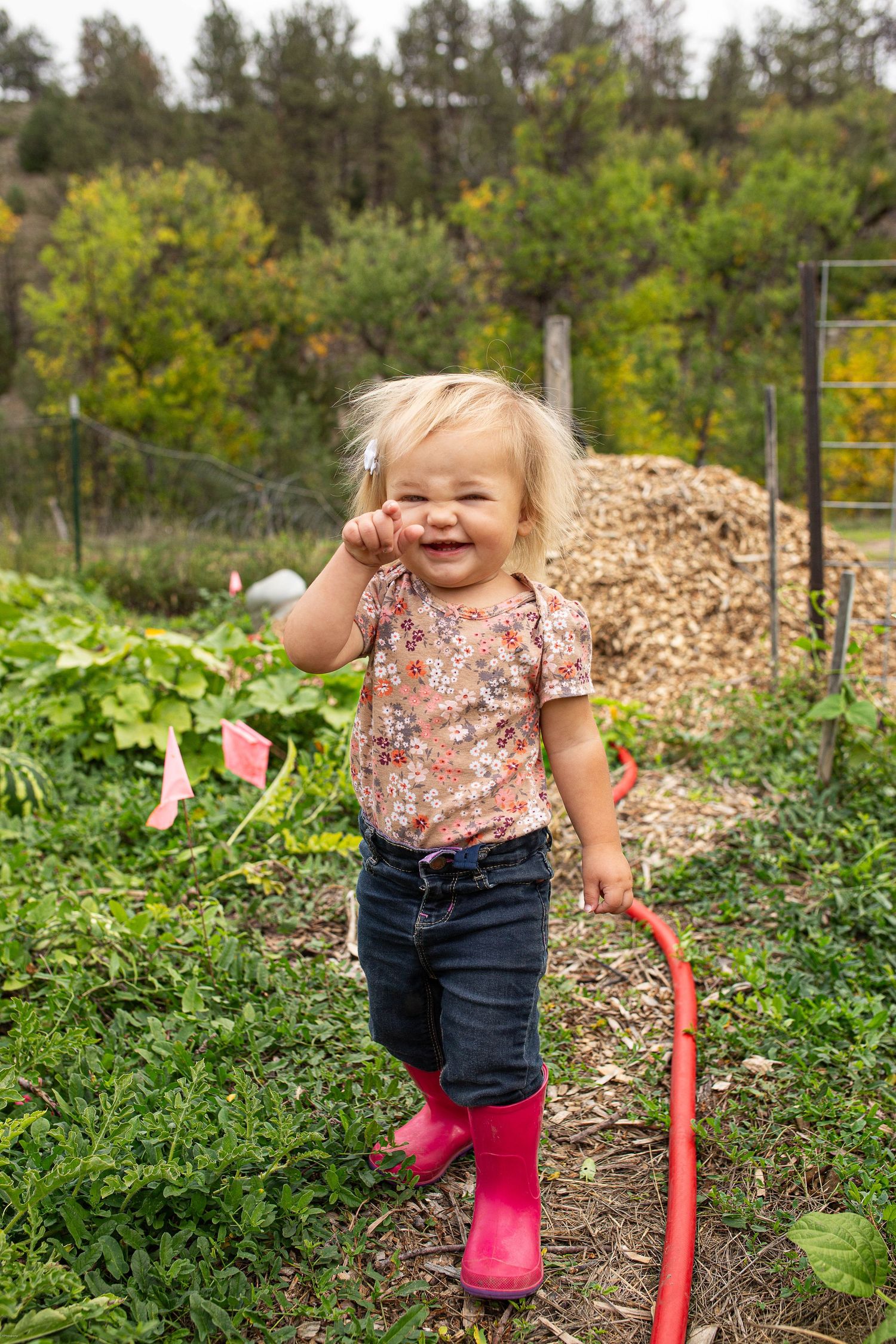 Baby girl exploring her garden at home.