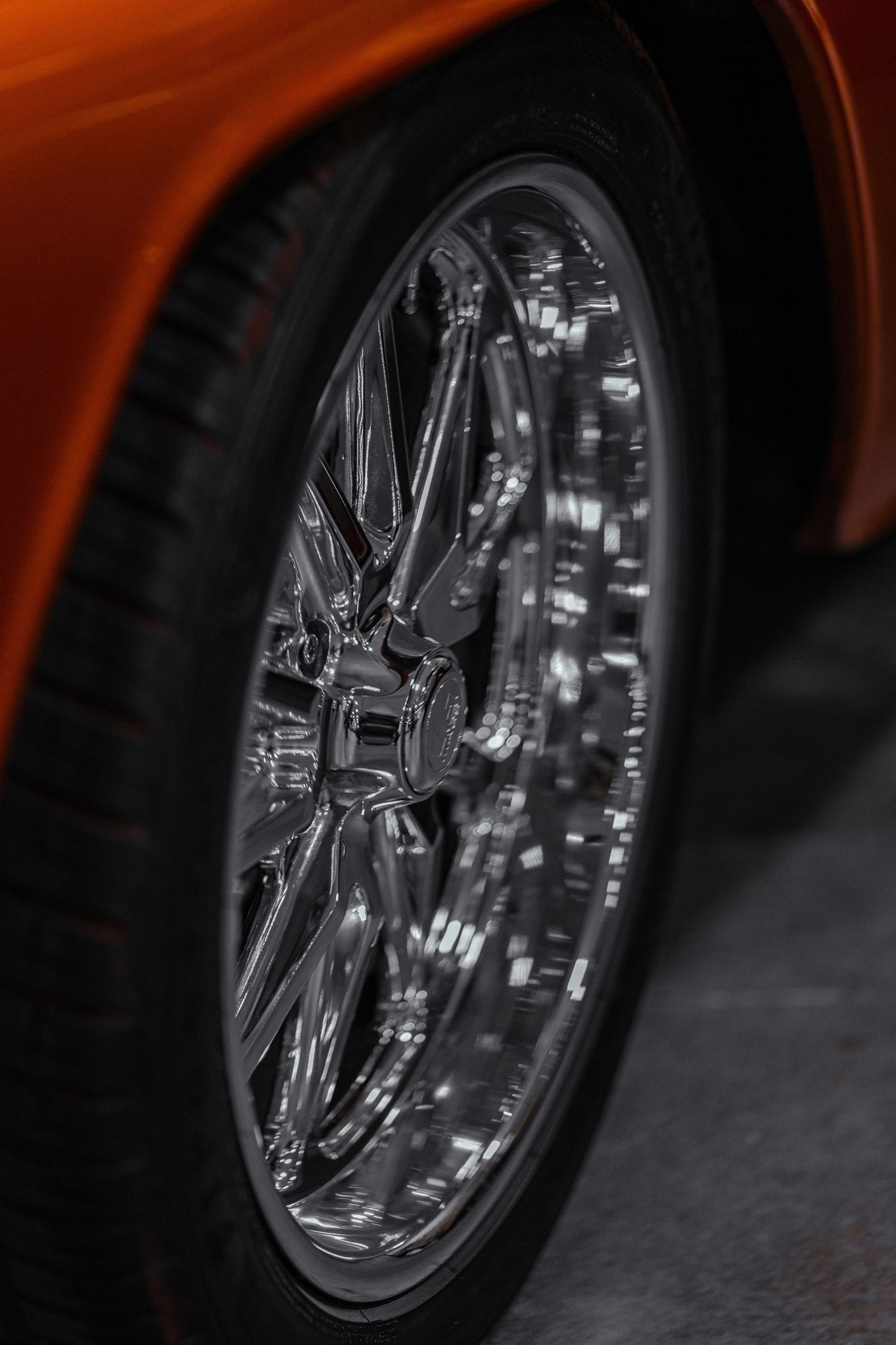 Close-up detail of chrome wheel rim and tire on custom vehicle.