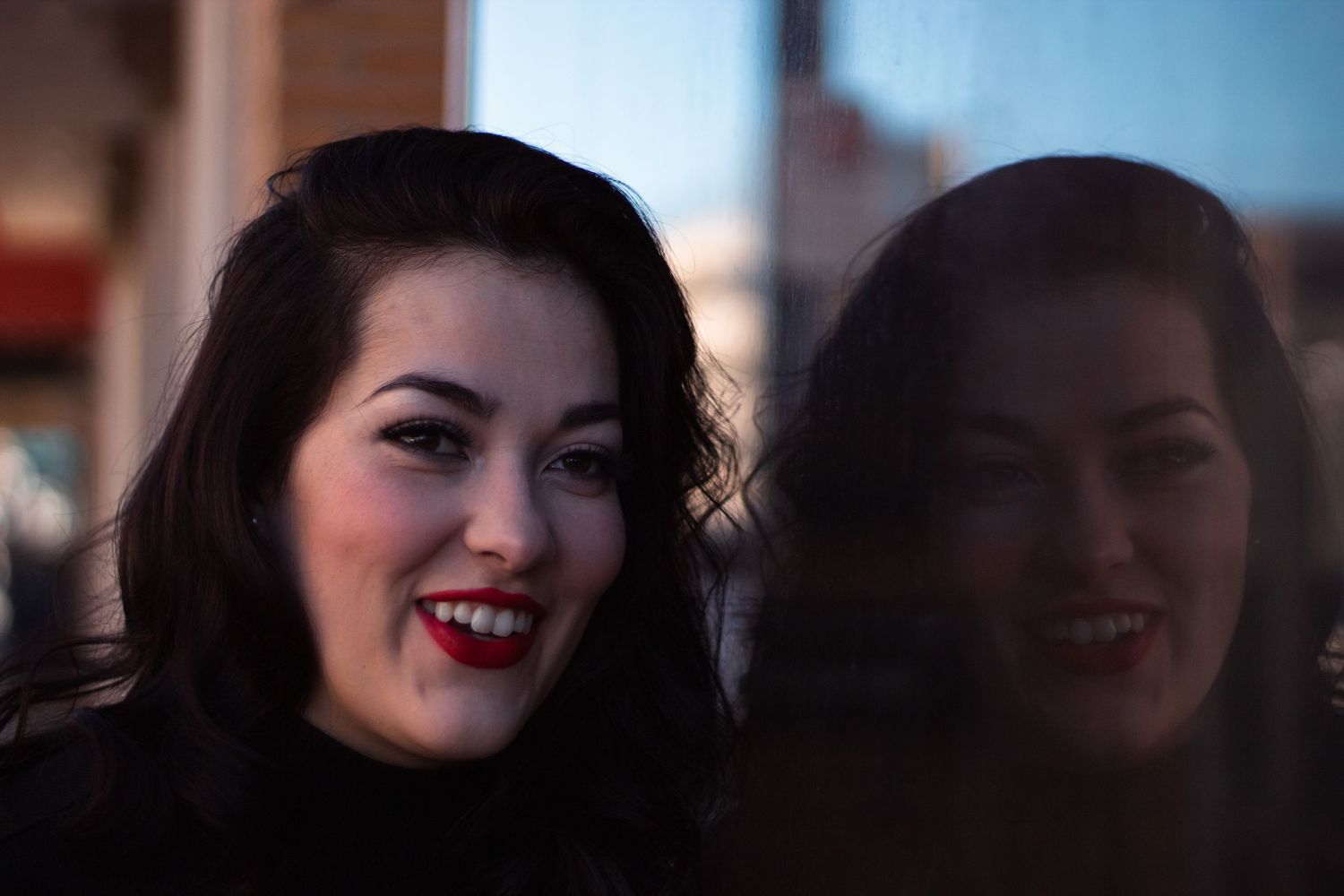 Artistic portrait photograph with soft bokeh lighting effects in dark setting.