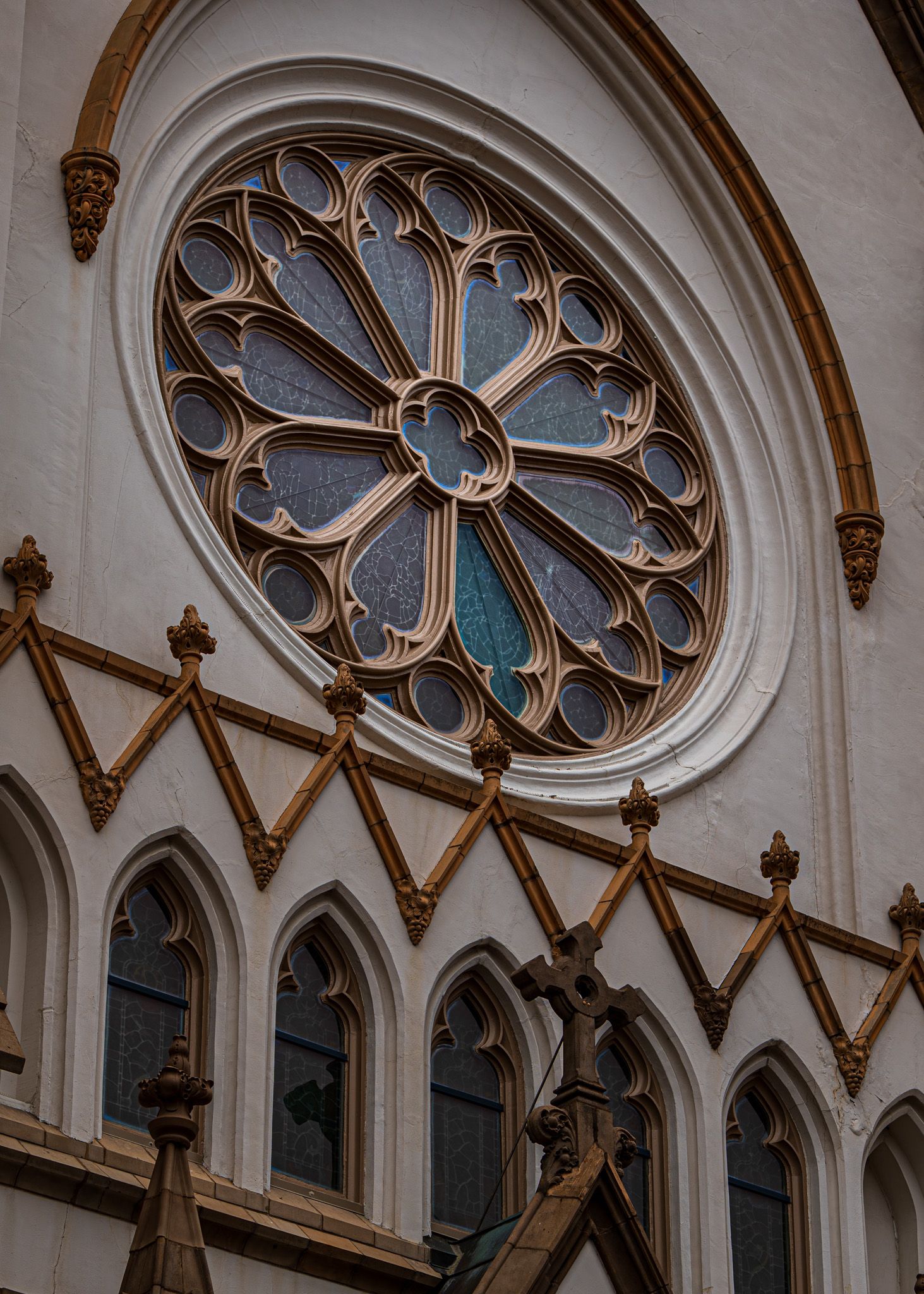 Ornate Gothic church architecture featuring pointed arches, rose windows and decorative stone tracery in white interior.